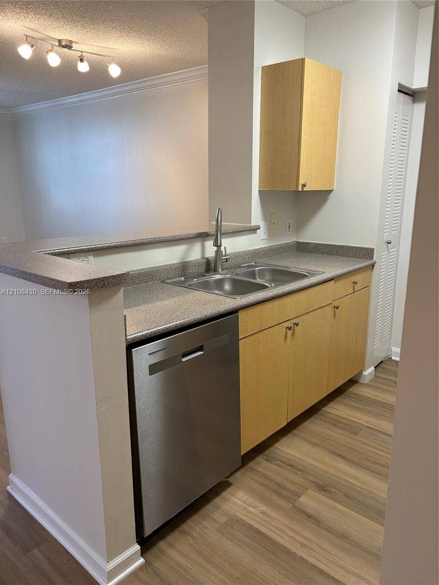 1919 Van Buren Street, #219A, Hollywood, FL 33020 Kitchen featuring light-finish cabinetry, stone-texture countertops, stainless steel dishwasher, dual-basin stainless steel sink with high-arc faucet, and wood-finish flooring