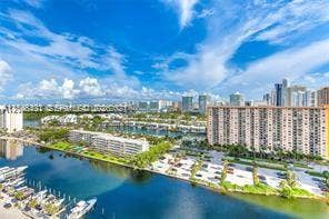 100 Bayview Drive, #1904, Sunny Isles Beach, Sunny Isles Beach, FL 33160 Aerial perspective of a waterway featuring boat slips, multi-story residential buildings, and surrounding urban infrastructure