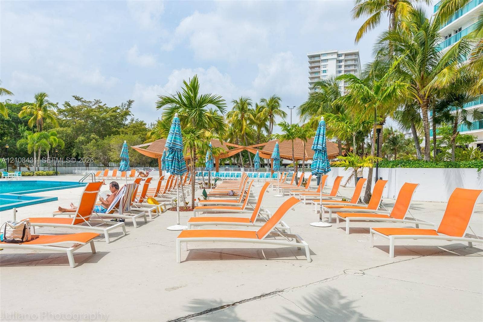 100 Bayview Drive, #1904, Sunny Isles Beach, Sunny Isles Beach, FL 33160 Swimming pool with expansive concrete pool deck, mature palm trees, and covered pavilion structure