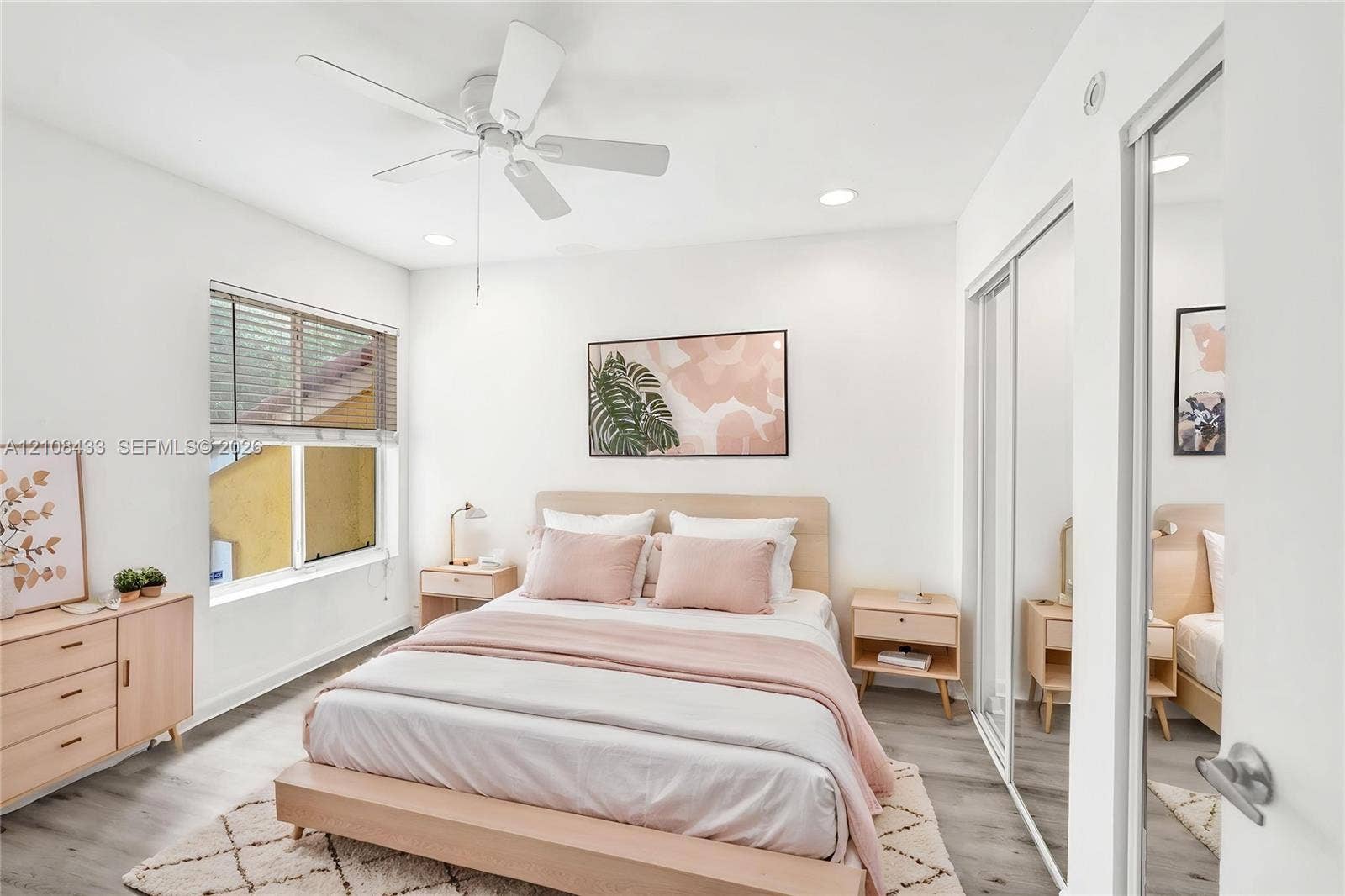 2300 NW 33rd Street, #911, Oakland Park, FL 33309 Bright room featuring wood-finish flooring, recessed lighting, a ceiling fan, and sliding mirrored closet doors