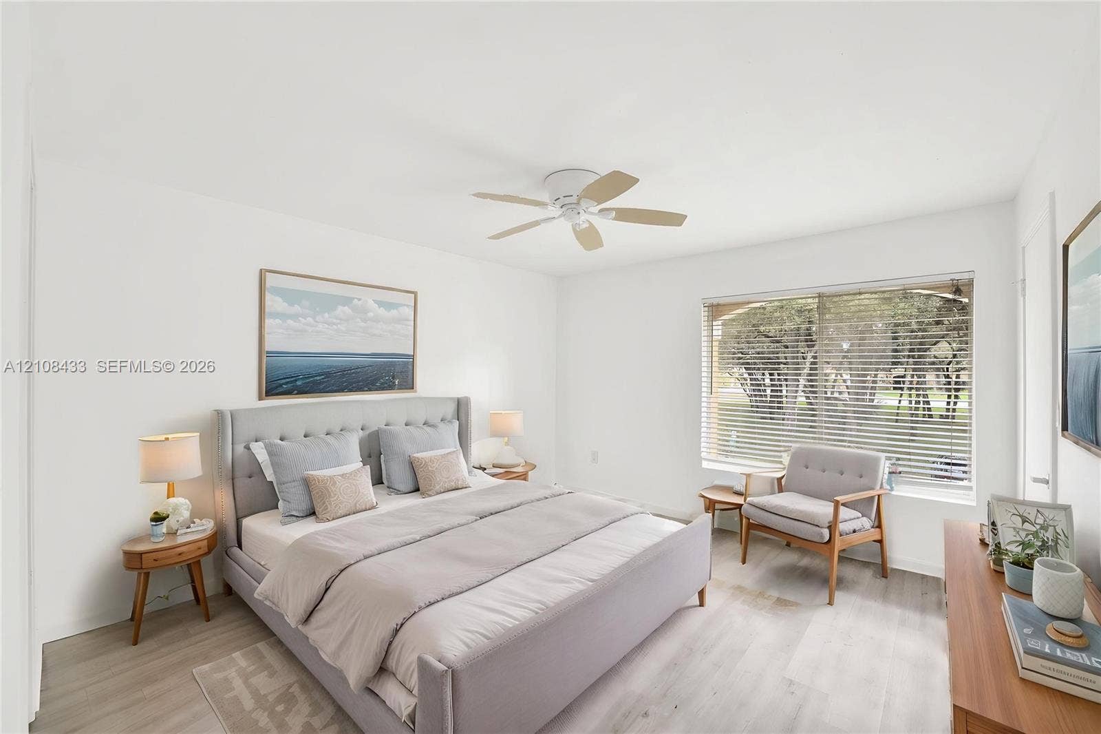 2300 NW 33rd Street, #911, Oakland Park, FL 33309 Light-filled room featuring wood-finish flooring, a white ceiling fan, and a large window