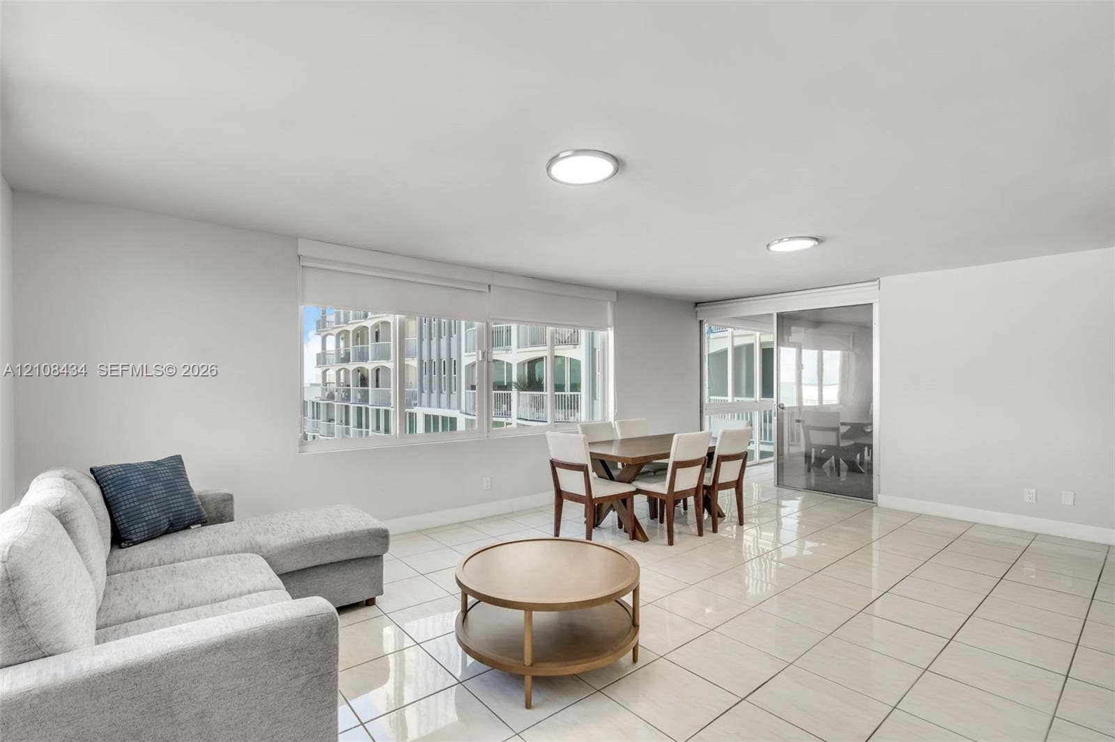Miami Beach, FL 33140 Open concept interior featuring large-format tile flooring, recessed LED lighting, expansive horizontal windows, and sliding glass balcony doors