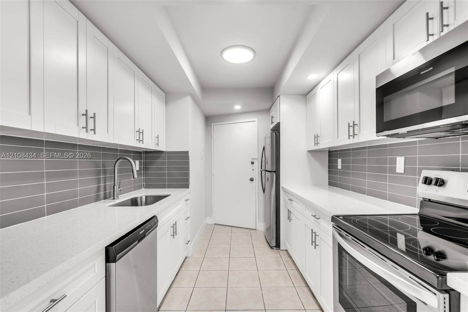 Miami Beach, FL 33140 Kitchen featuring white shaker-style cabinetry, white countertops, gray subway tile backsplash, stainless steel appliances, and tile flooring