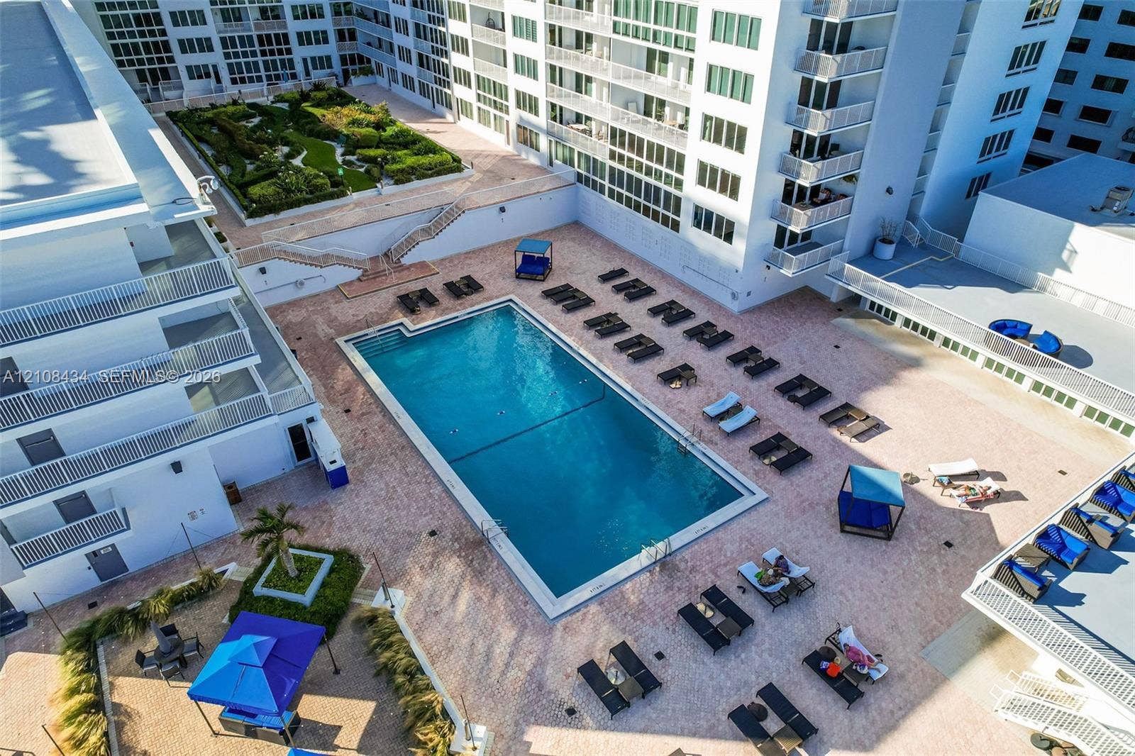 Miami Beach, FL 33140 Outdoor swimming pool featuring a paved pool deck and multi-level landscaped gardens