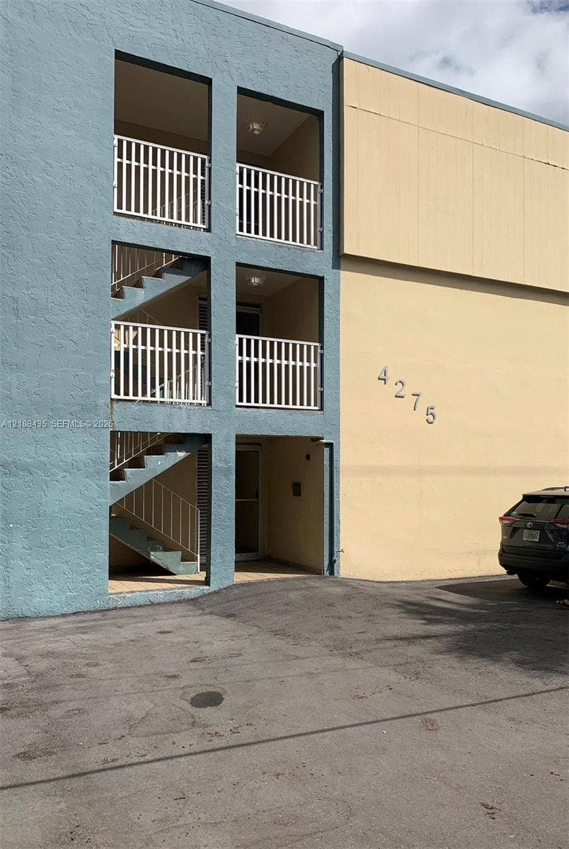 4275 S Tamiami Canal Drive, #2-314, Miami, Miami, FL 33126 Exterior facade featuring smooth stucco finishes, tiered open-air balconies with metal railings, and integrated staircases