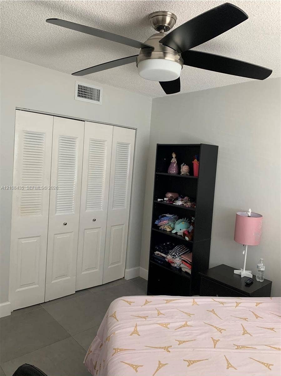 4275 S Tamiami Canal Drive, #2-314, Miami, Miami, FL 33126 Brushed nickel ceiling fan with matte black blades and integrated light fixture, paired with four-panel louvered closet doors