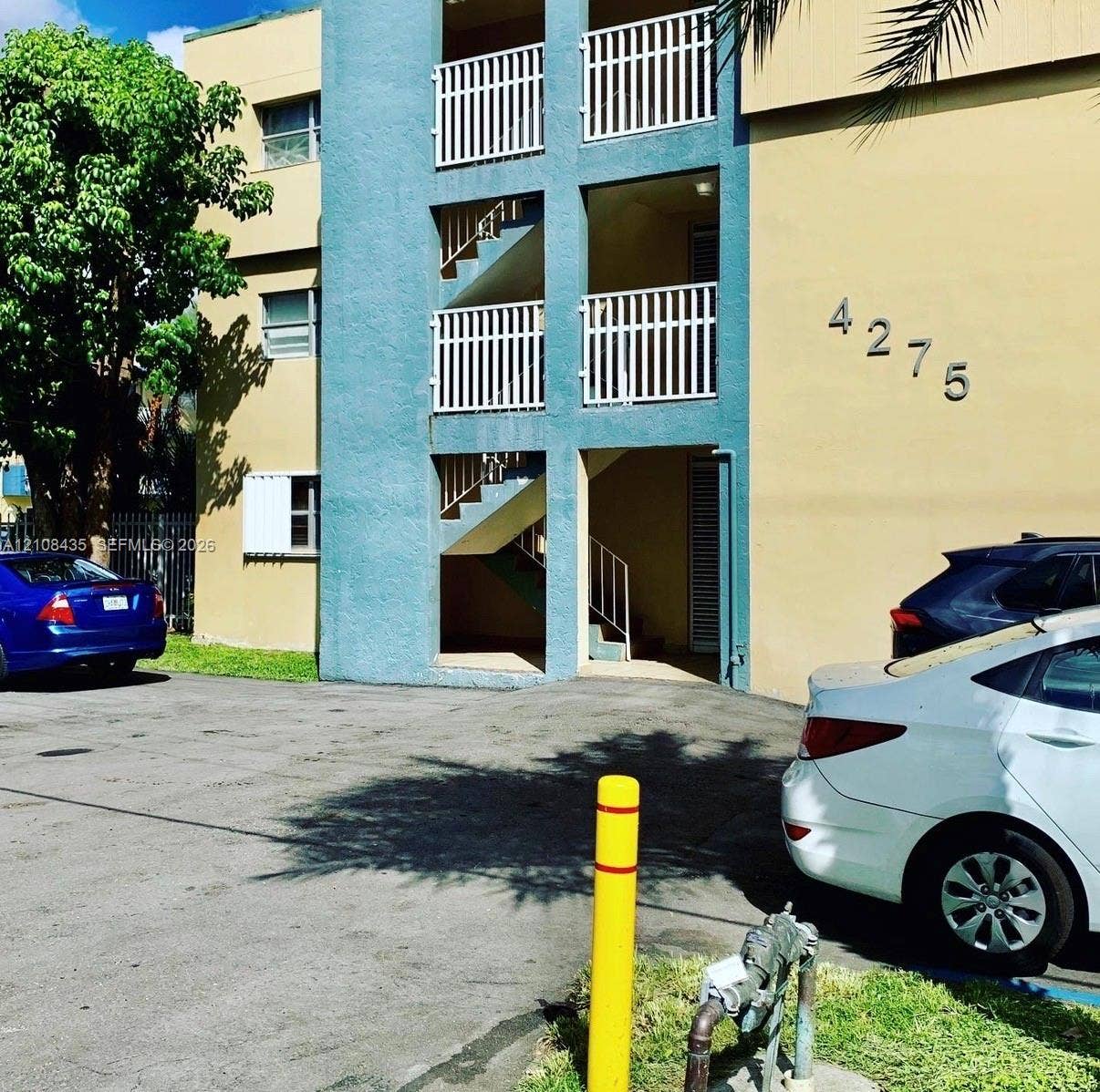4275 S Tamiami Canal Drive, #2-314, Miami, Miami, FL 33126 Multi-story exterior featuring a stucco facade, white metal balcony railings, and exterior staircases