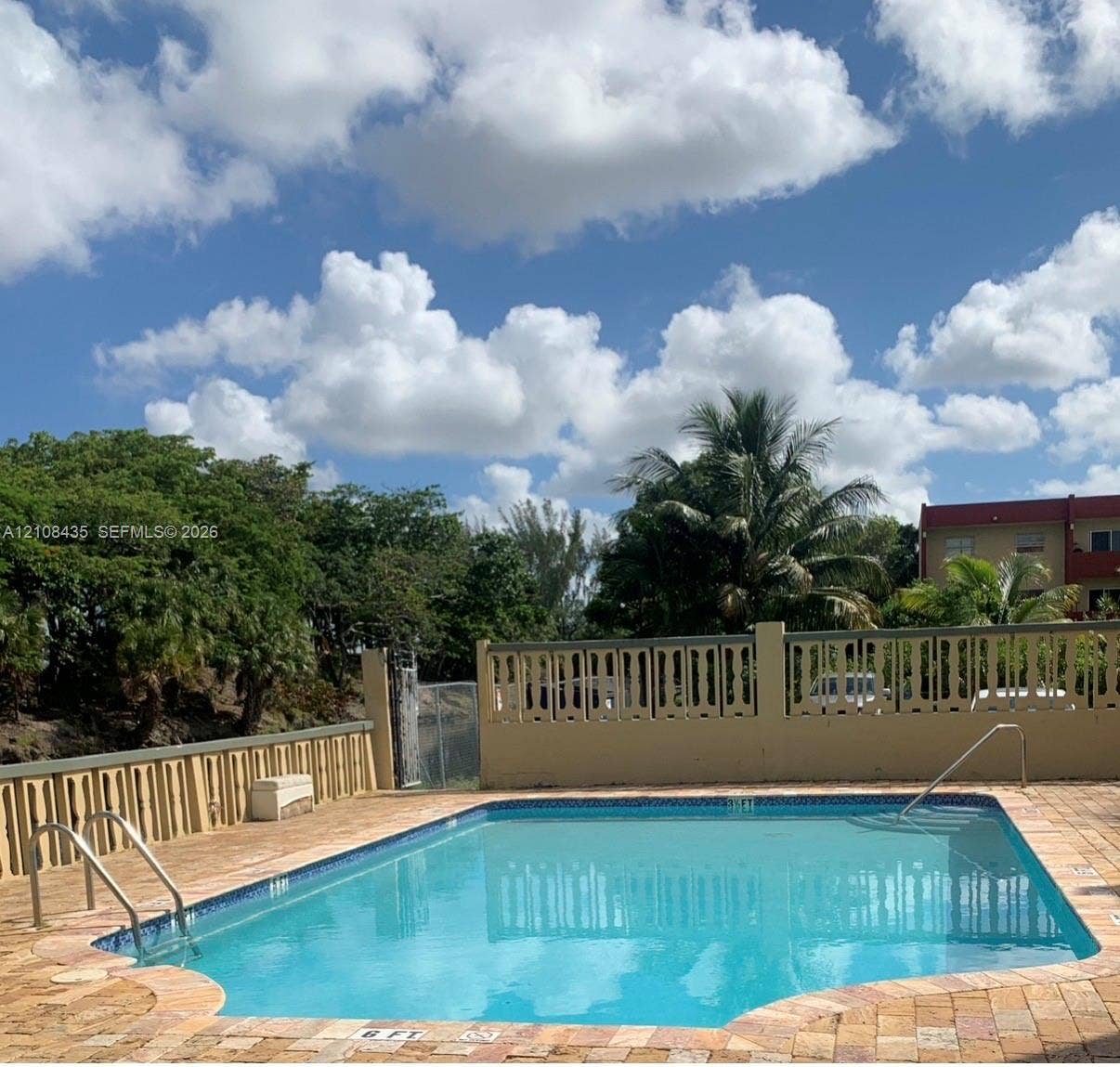 4275 S Tamiami Canal Drive, #2-314, Miami, Miami, FL 33126 Inground swimming pool with tile trim, decorative concrete privacy wall, and brick paver decking