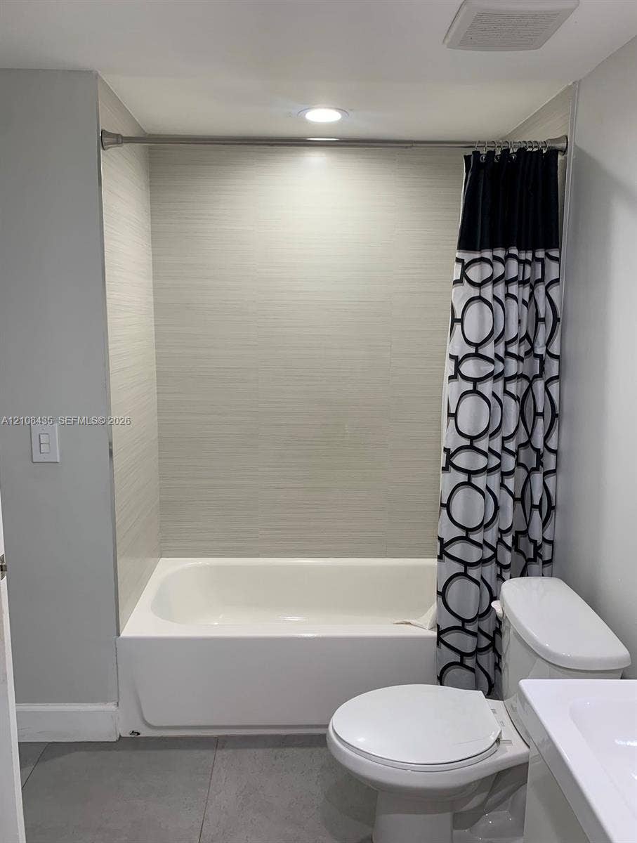 4275 S Tamiami Canal Drive, #2-314, Miami, Miami, FL 33126 Bathtub surround featuring horizontally-aligned neutral-toned textured tile, recessed ceiling lighting, and large-format floor tile