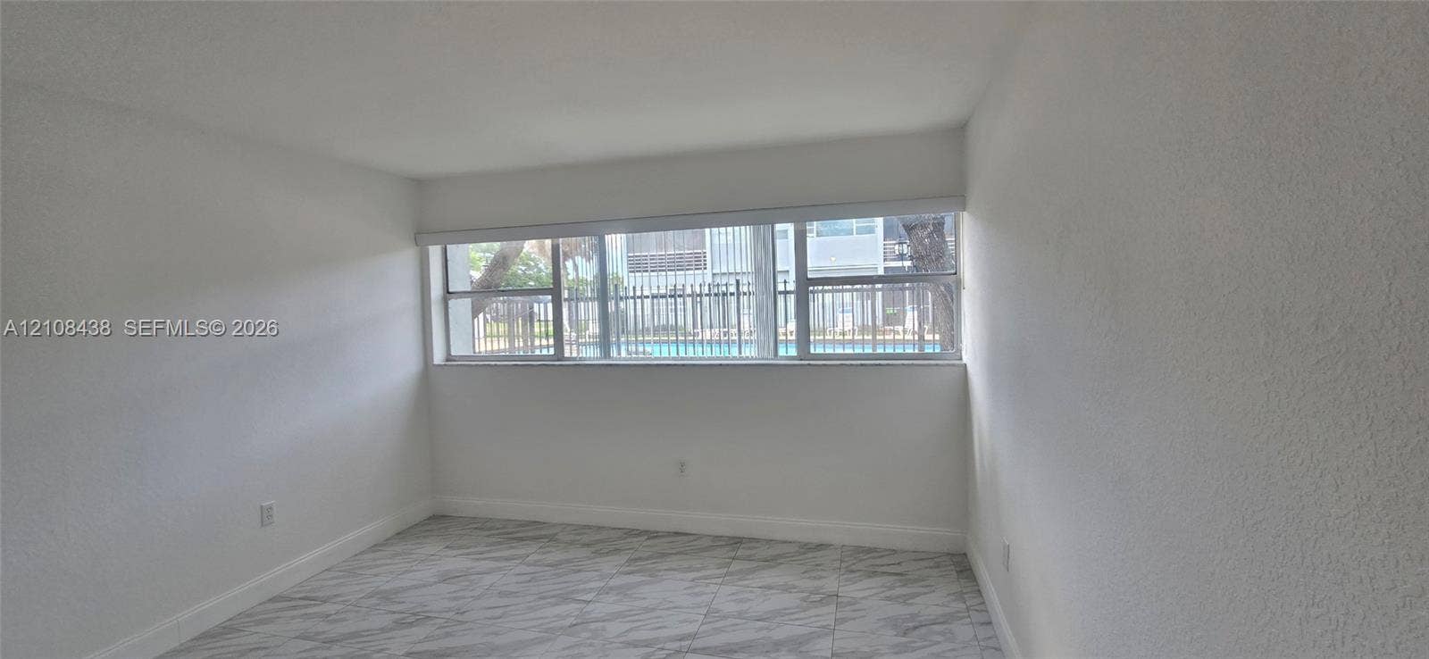 7320 NW 85th Court, #102, Tamarac, FL 33321 Interior space featuring large-format tile flooring and expansive horizontal windows