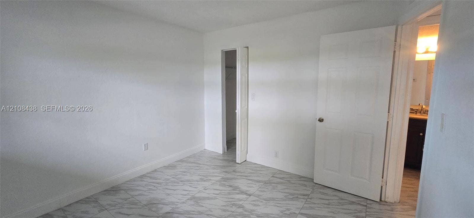 7320 NW 85th Court, #102, Tamarac, FL 33321 Neutral-toned interior space featuring stone-finish flooring and a walk-in closet with bifold door