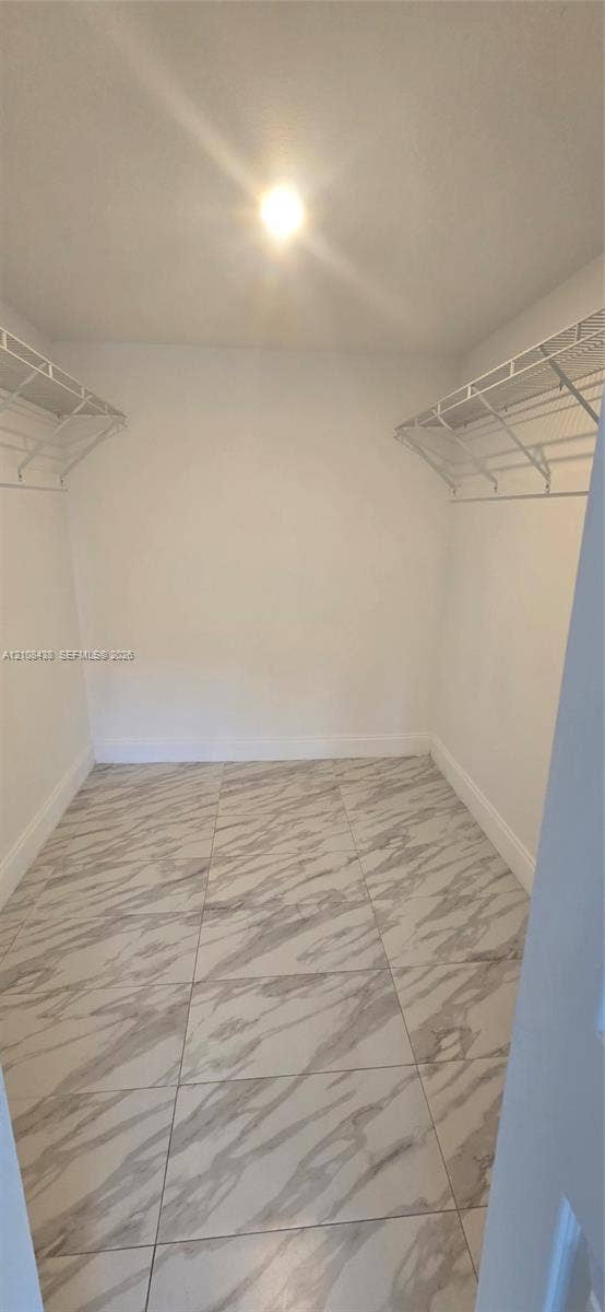 7320 NW 85th Court, #102, Tamarac, FL 33321 Walk-in closet featuring large-format tile flooring and dual-level wire shelving
