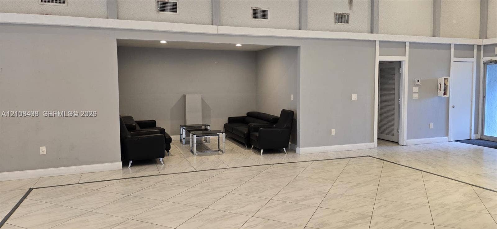 7320 NW 85th Court, #102, Tamarac, FL 33321 Large open interior space featuring recessed ceiling lighting, light-toned tile flooring with contrasting border inlay, and a dedicated recessed alcove