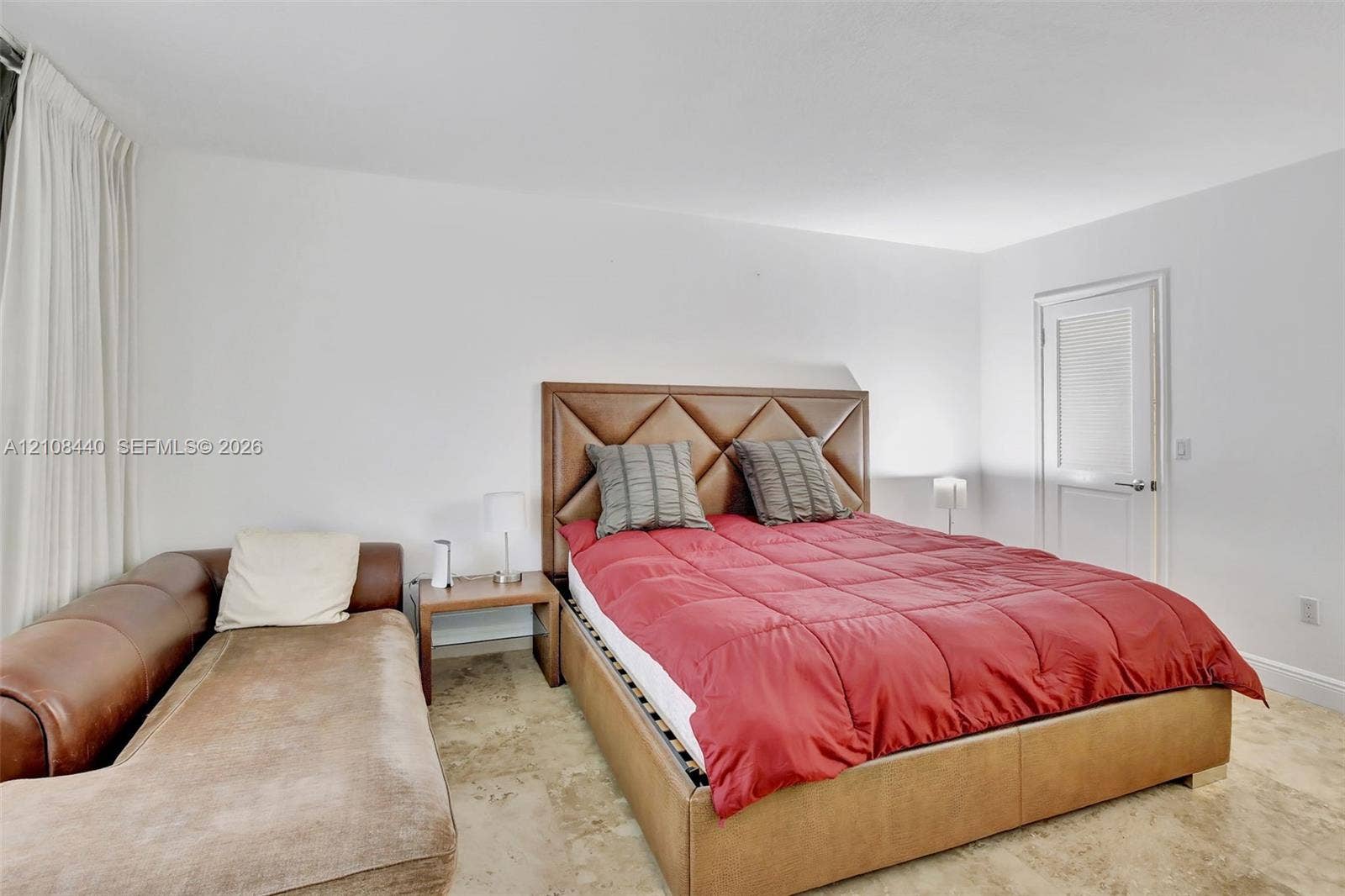 9801 Collins Avenue, #3T, Bal Harbour, Bal Harbour, FL 33154 Neutral-toned stone flooring and a white paneled door with a brushed-metal lever handle