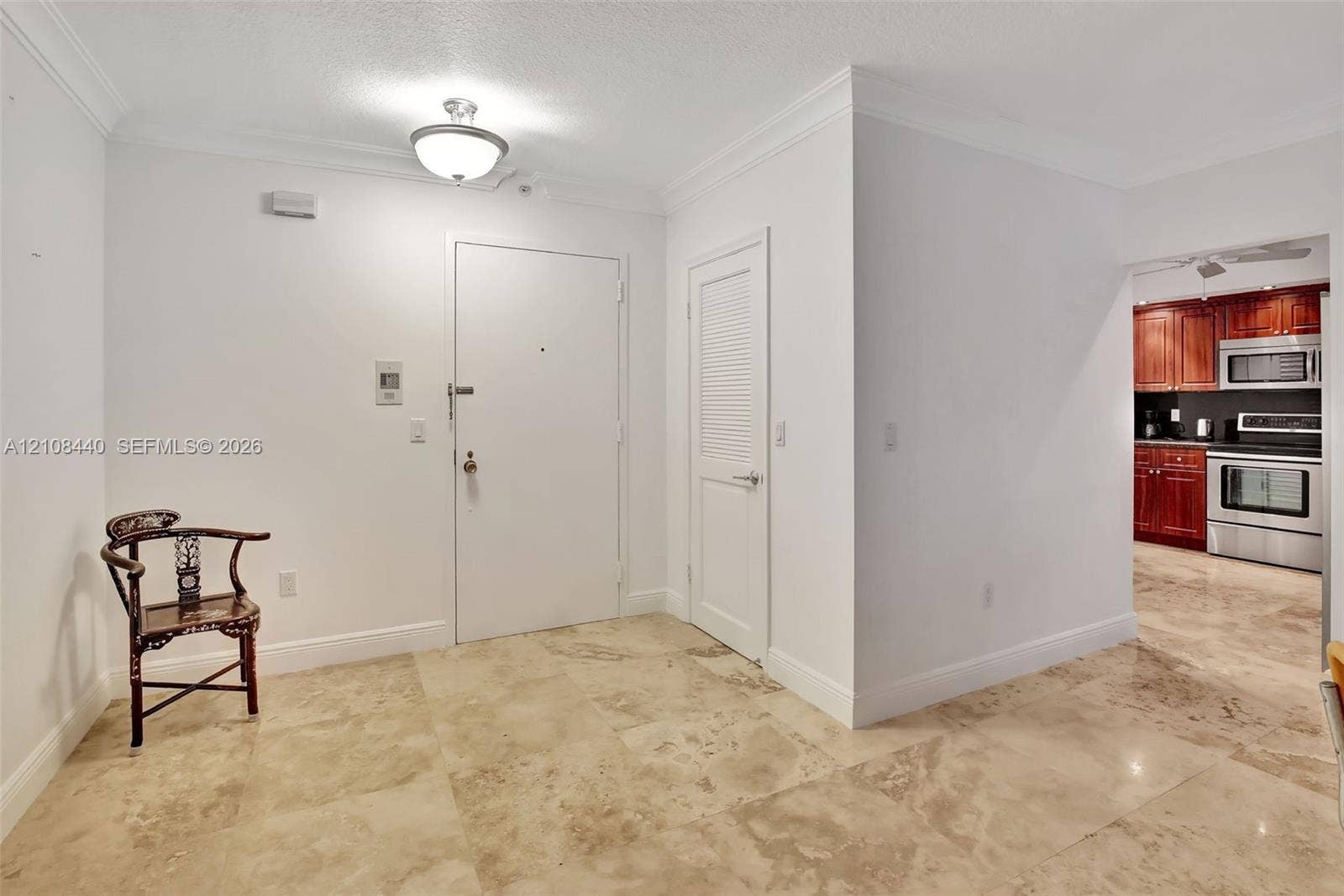 9801 Collins Avenue, #3T, Bal Harbour, Bal Harbour, FL 33154 Neutral-tone tile flooring, crown molding, semi-flush mount ceiling light, and louvered-panel door
