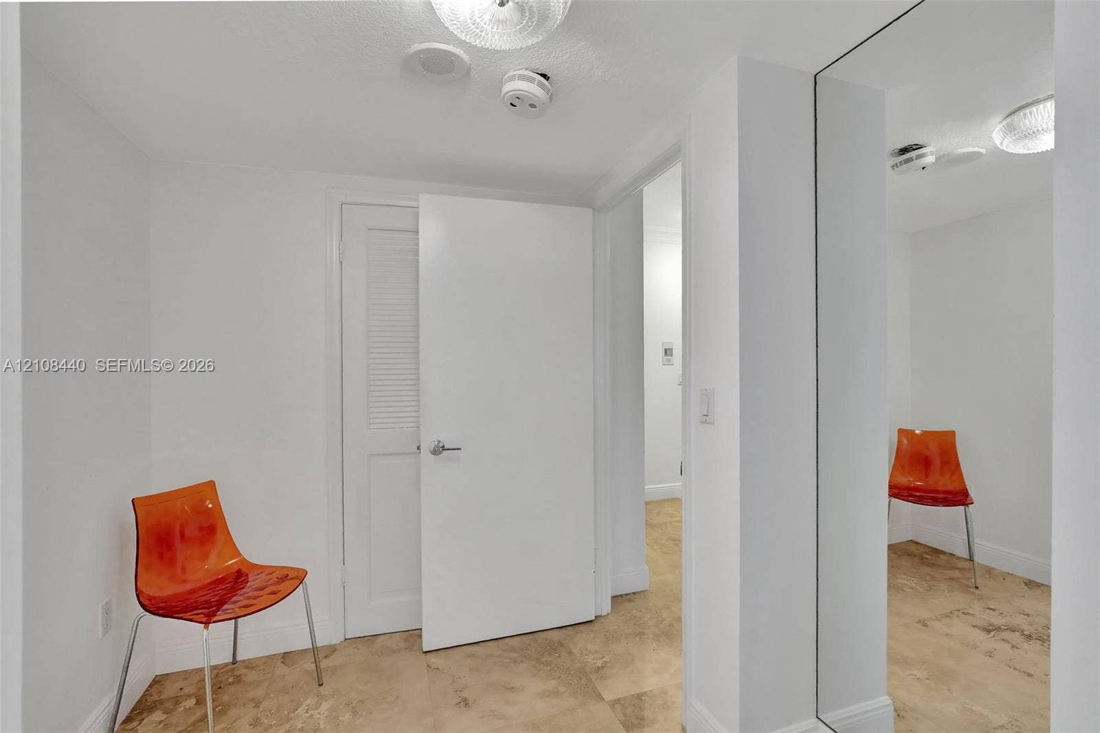 9801 Collins Avenue, #3T, Bal Harbour, Bal Harbour, FL 33154 Interior space featuring stone tile flooring, full-height wall mirror, and a louvered closet door