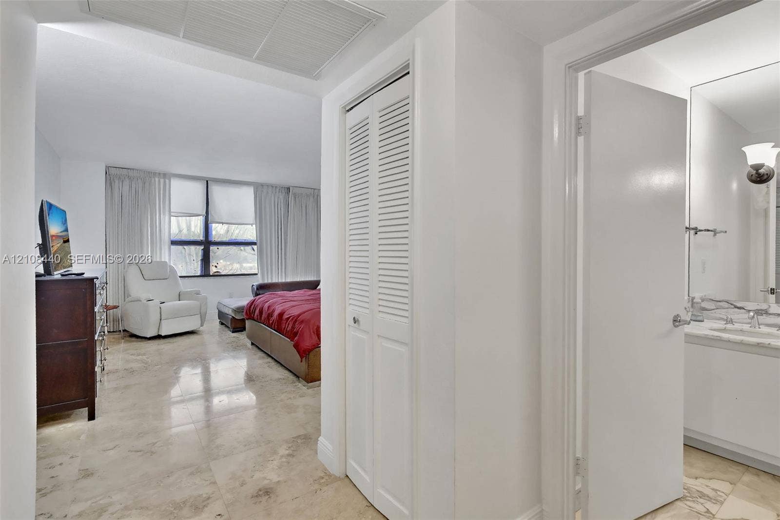 9801 Collins Avenue, #3T, Bal Harbour, Bal Harbour, FL 33154 Polished stone flooring, floor-to-ceiling windows, and white bifold closet doors