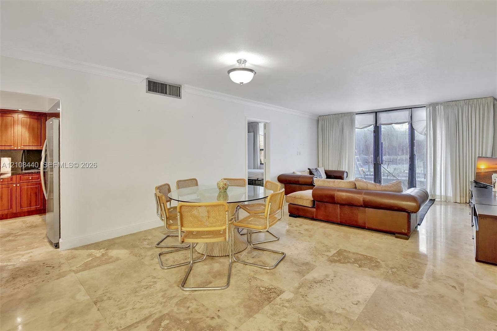 9801 Collins Avenue, #3T, Bal Harbour, Bal Harbour, FL 33154 Open-concept living space featuring polished stone flooring, ceiling-mounted light fixtures, crown molding, and floor-to-ceiling glass panel doors