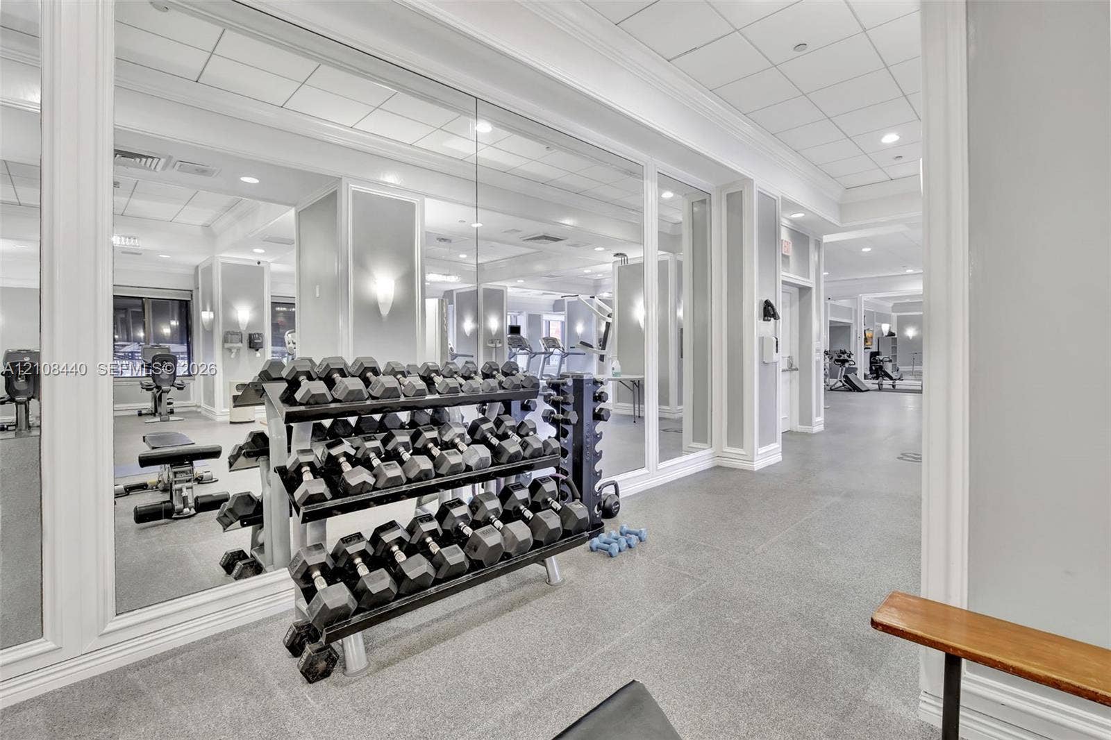 9801 Collins Avenue, #3T, Bal Harbour, Bal Harbour, FL 33154 Fitness facility featuring wall-to-wall mirrors, recessed lighting, drop ceiling panels, and durable composite flooring