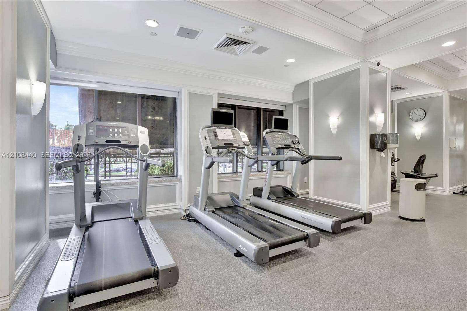 9801 Collins Avenue, #3T, Bal Harbour, Bal Harbour, FL 33154 Fitness center featuring large windows, recessed ceiling lighting, wall-mounted sconces, and crown molding