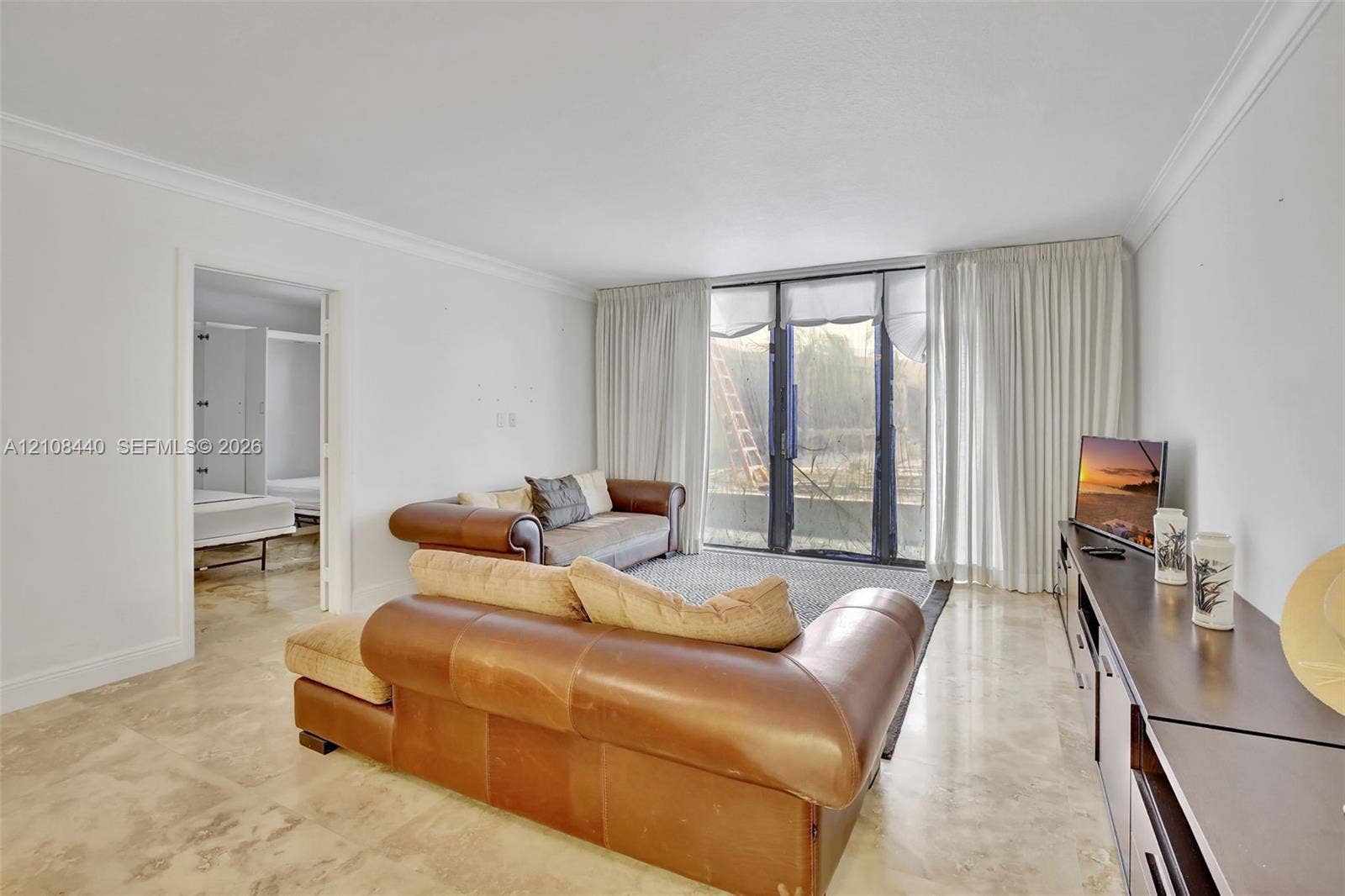 9801 Collins Avenue, #3T, Bal Harbour, Bal Harbour, FL 33154 Living space featuring polished stone flooring, crown molding, and floor-to-ceiling glass sliding doors