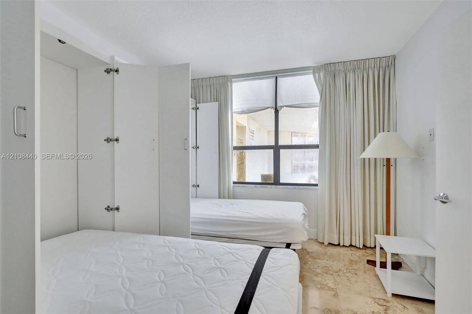 9801 Collins Avenue, #3T, Bal Harbour, Bal Harbour, FL 33154 Built-in white cabinetry, natural stone flooring, and large window with dark-frame panes