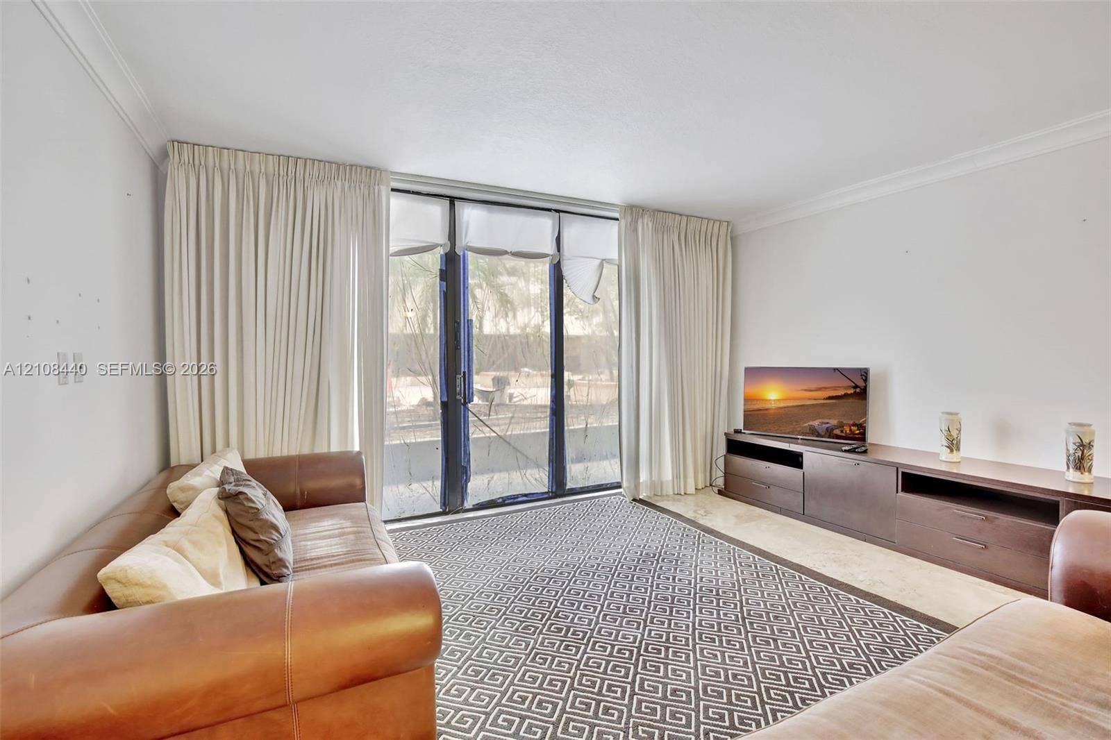 9801 Collins Avenue, #3T, Bal Harbour, Bal Harbour, FL 33154 Living space featuring full-height floor-to-ceiling glass sliding doors, neutral stone-finish flooring, and crown molding