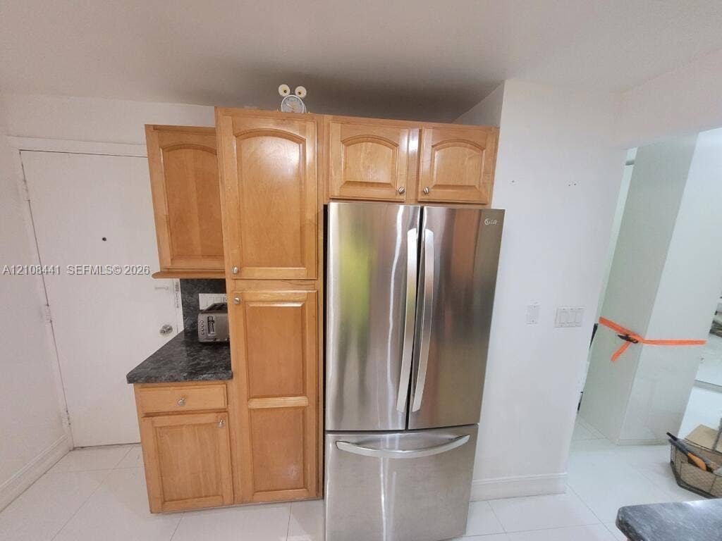 3703 NE 166th Street, #401, North Miami Beach, North Miami Beach, FL 33160 Natural wood cabinetry, stainless steel French-door refrigerator, and dark stone-finish countertops