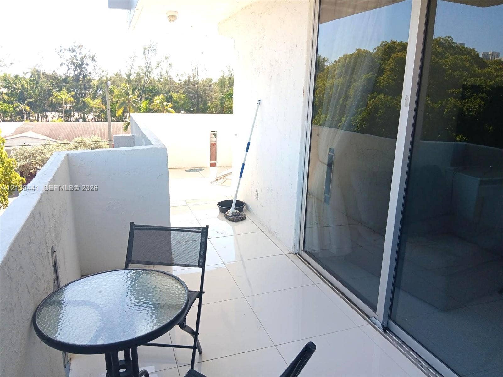 3703 NE 166th Street, #401, North Miami Beach, North Miami Beach, FL 33160 Private balcony featuring large-format tile flooring, textured stucco walls, and sliding glass door entry