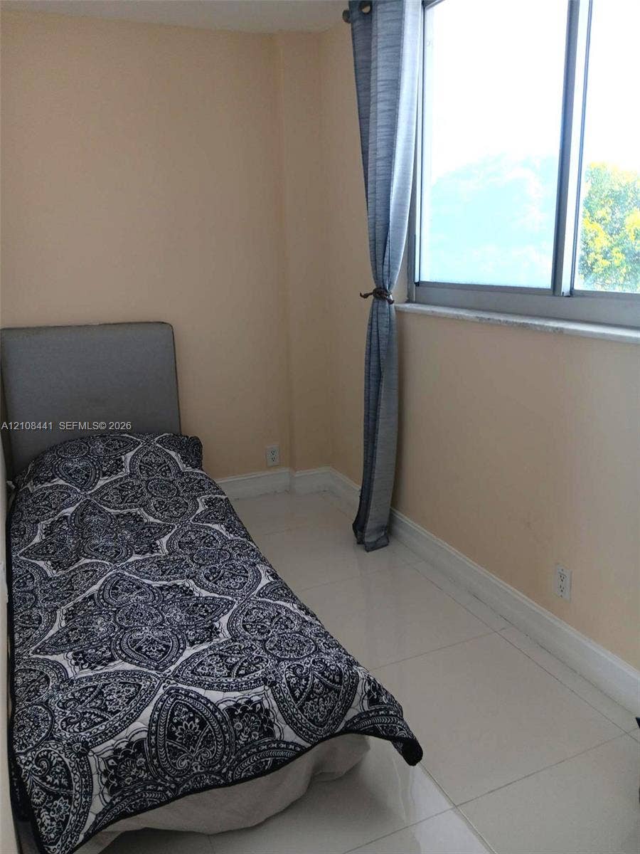 3703 NE 166th Street, #401, North Miami Beach, North Miami Beach, FL 33160 Neutral interior room featuring large-format tile flooring, oversized horizontal window, and stone window sill