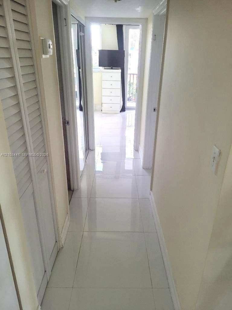 3703 NE 166th Street, #401, North Miami Beach, North Miami Beach, FL 33160 Large-format porcelain tile flooring and louvered bi-fold closet doors