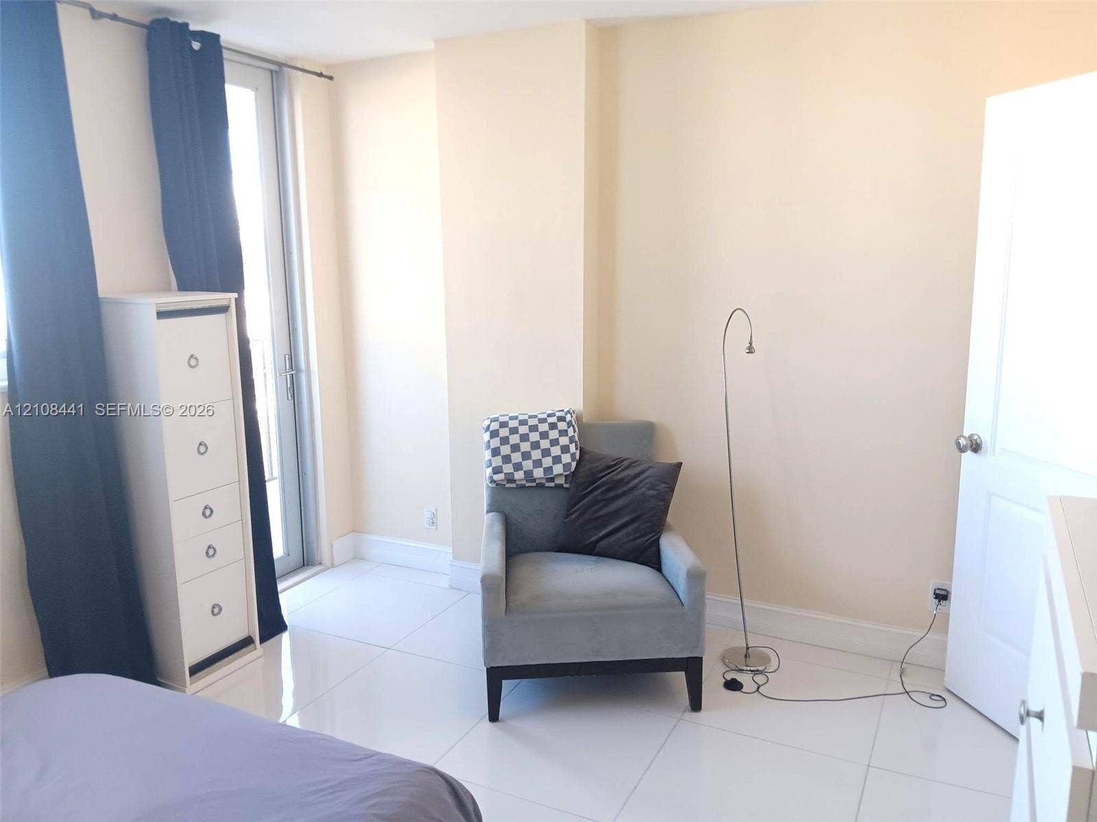 3703 NE 166th Street, #401, North Miami Beach, North Miami Beach, FL 33160 Bright room featuring high-gloss tile flooring and a glass-paned door providing exterior access