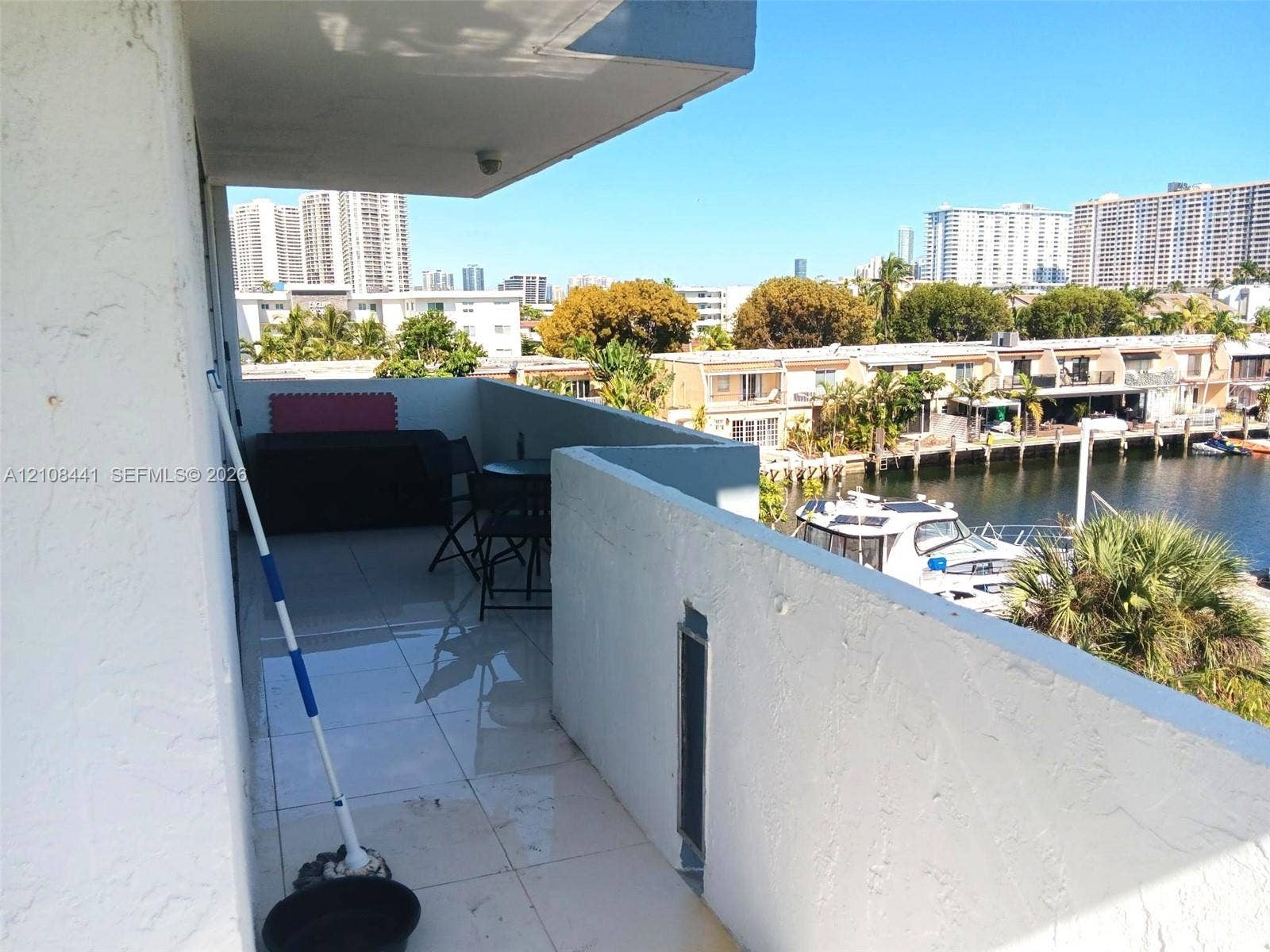 3703 NE 166th Street, #401, North Miami Beach, North Miami Beach, FL 33160 Covered balcony featuring white tile flooring and concrete masonry walls overlooking the canal