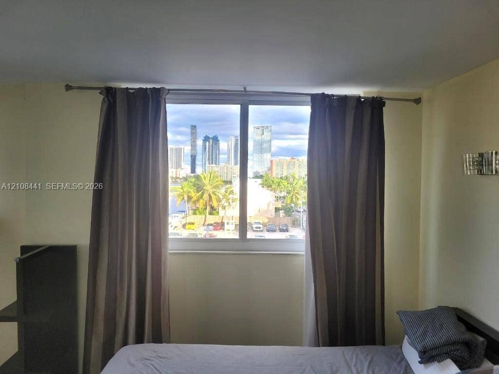 3703 NE 166th Street, #401, North Miami Beach, North Miami Beach, FL 33160 Large window with a skyline backdrop and wall-mounted metal light fixture