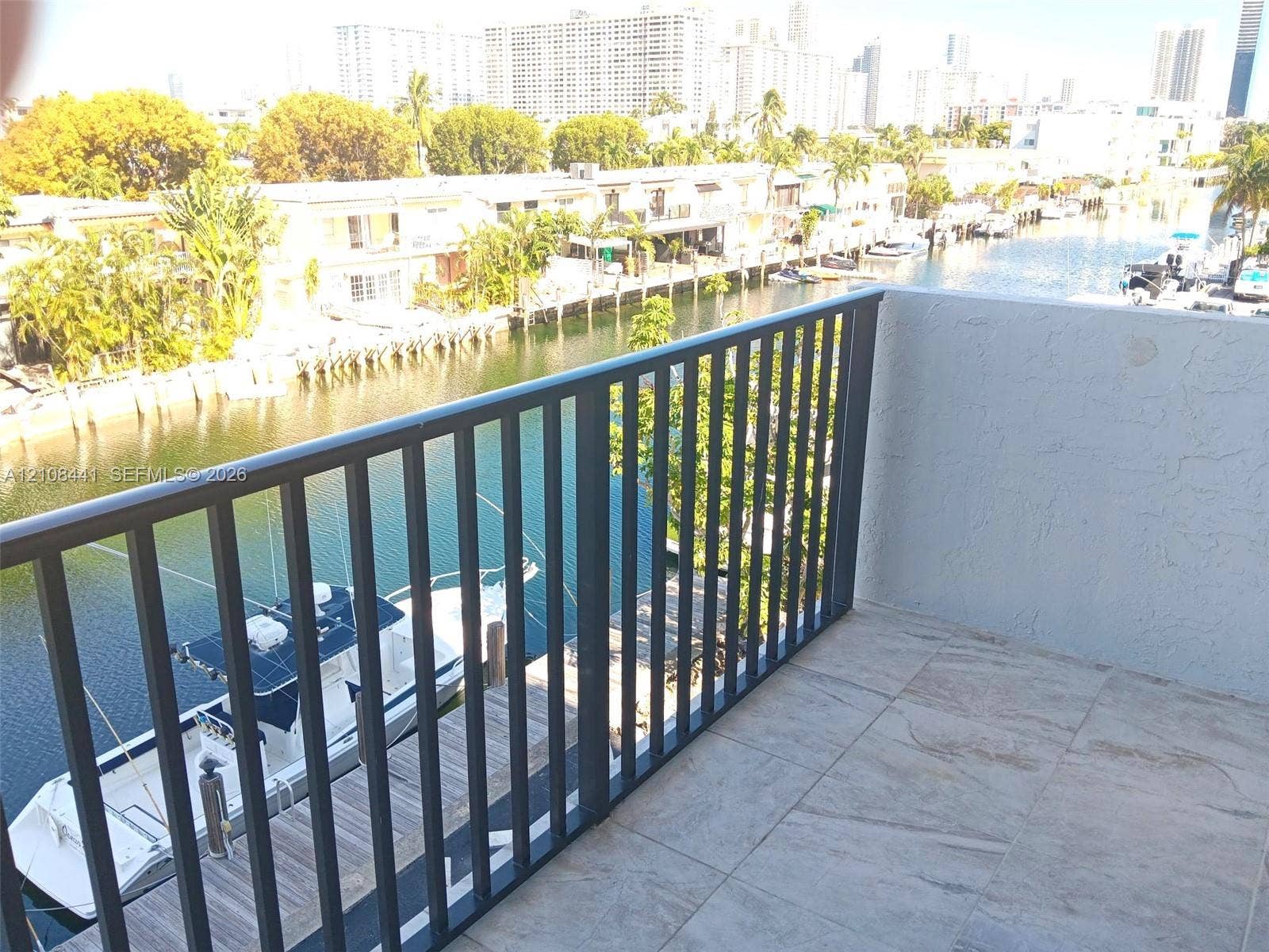 3703 NE 166th Street, #401, North Miami Beach, North Miami Beach, FL 33160 Private balcony featuring tile flooring and metal railing, overlooking the canal and waterfront area