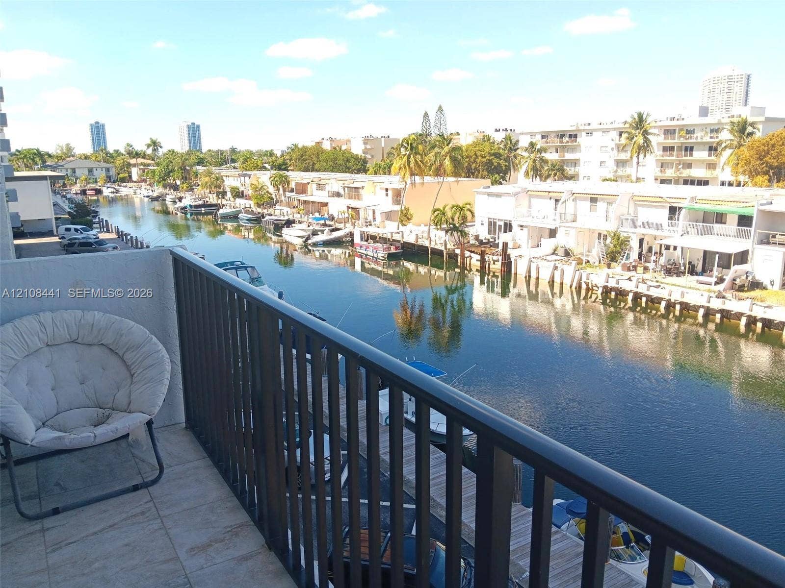 3703 NE 166th Street, #401, North Miami Beach, North Miami Beach, FL 33160 Balcony featuring tile flooring and a metal railing overlooking a canal with boat slips