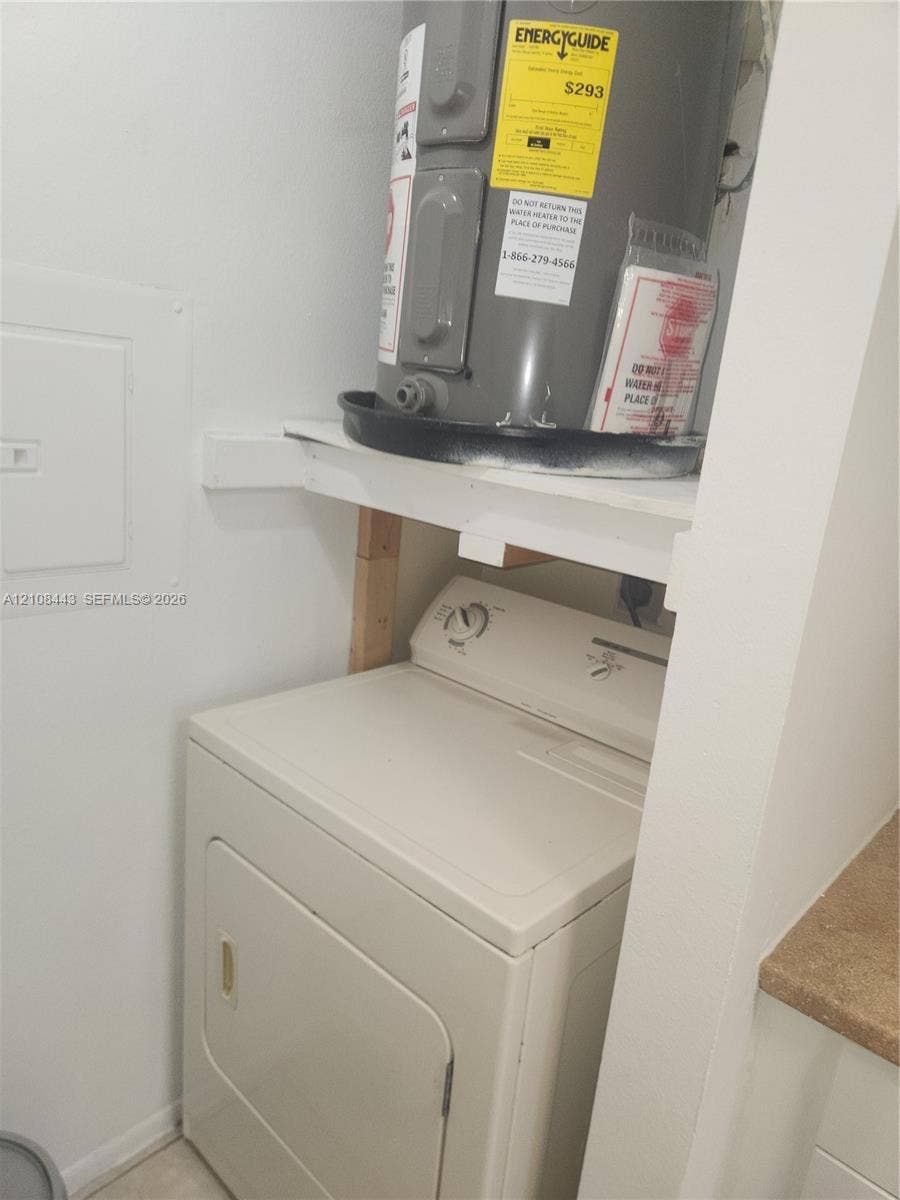 4018 NW 87th Avenue, #4018, Sunrise, Sunrise, FL 33351 Utility closet featuring an electric water heater housed on a support shelf above a clothes dryer