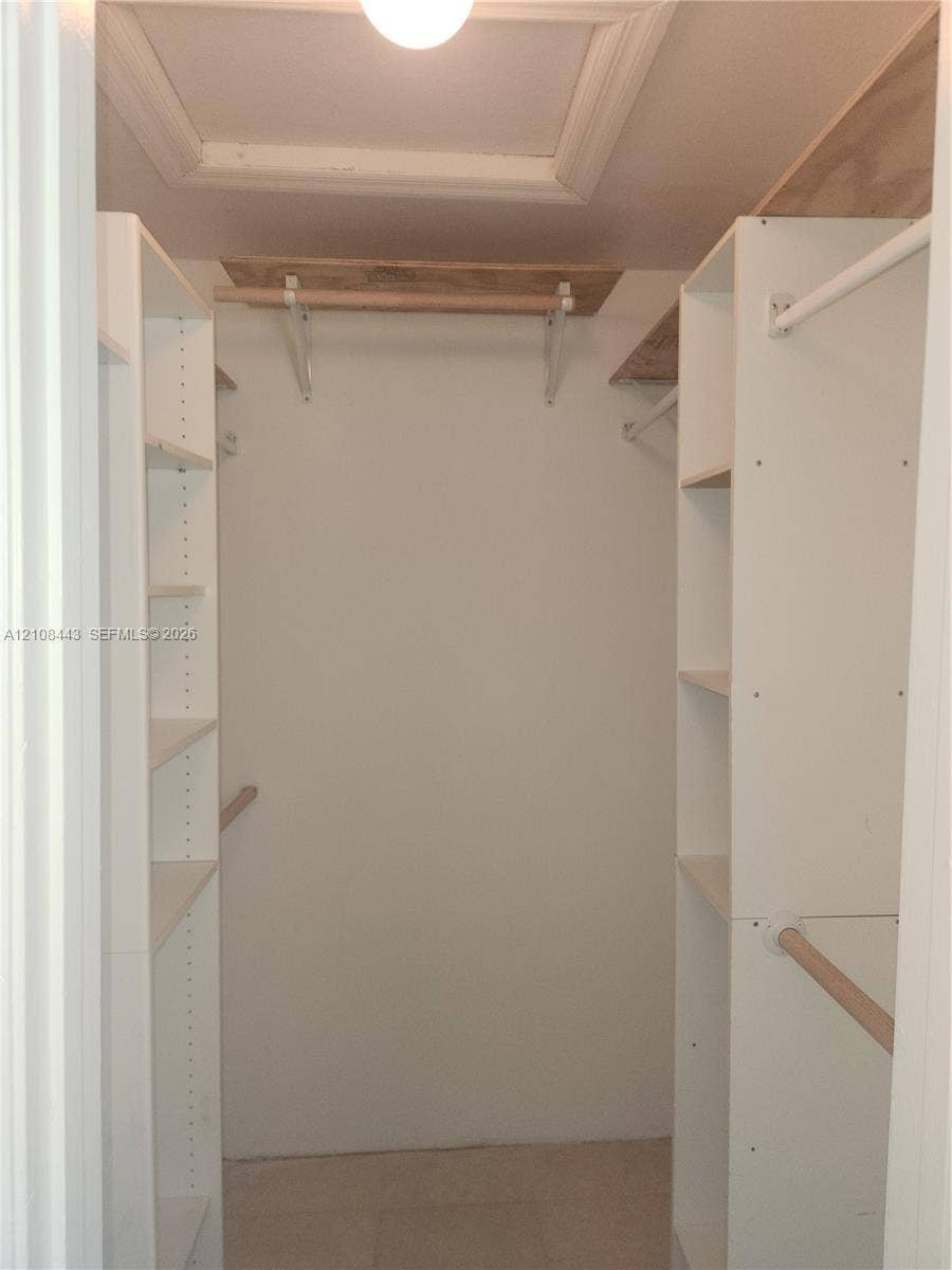 4018 NW 87th Avenue, #4018, Sunrise, Sunrise, FL 33351 Storage space featuring white built-in shelving towers, wooden hanging rods, and upper wood-finish shelving