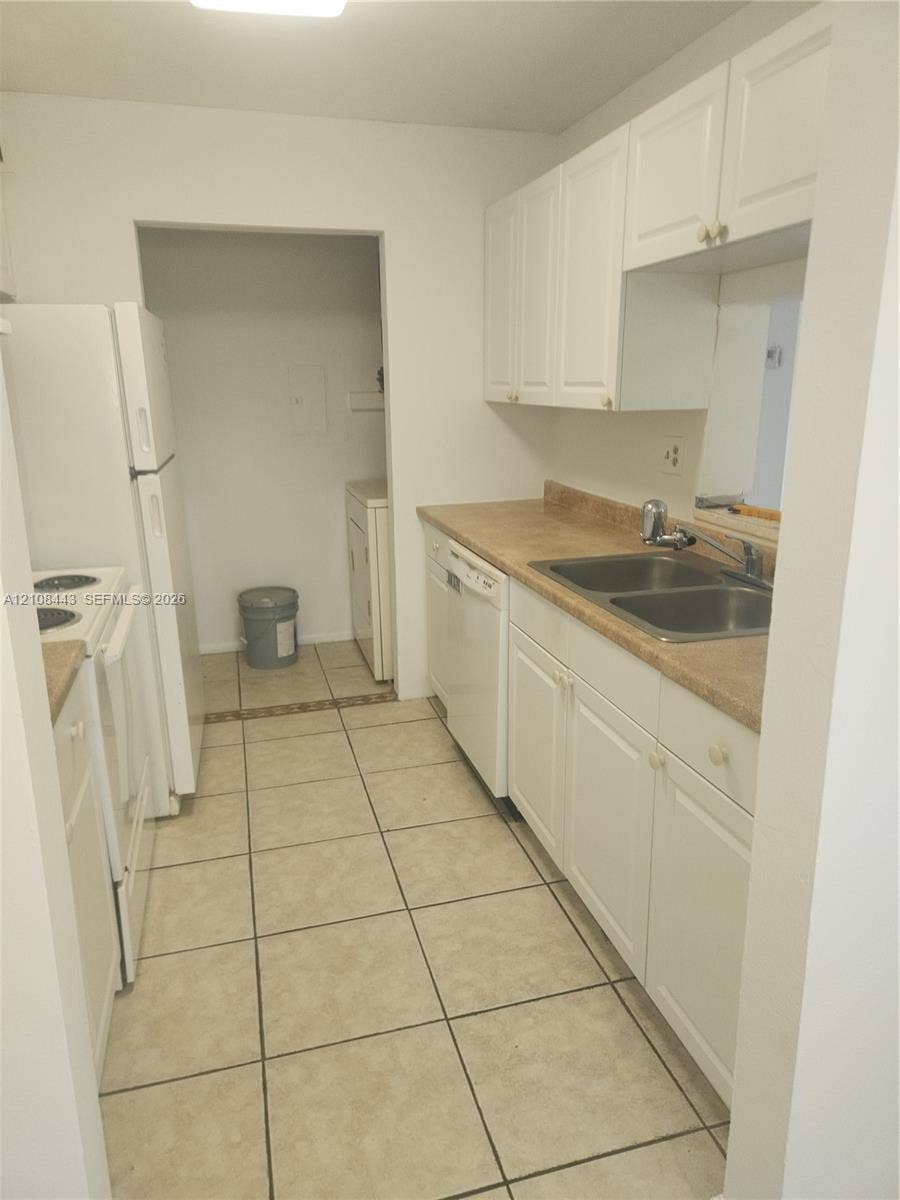 4018 NW 87th Avenue, #4018, Sunrise, Sunrise, FL 33351 Kitchen featuring white cabinetry, solid-surface countertops, dual-basin stainless steel sink, built-in dishwasher, and ceramic tile flooring