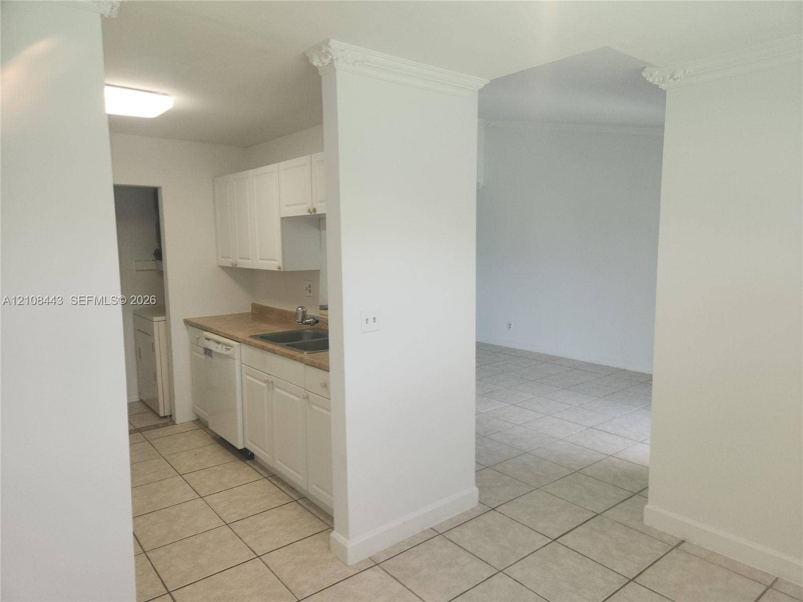 4018 NW 87th Avenue, #4018, Sunrise, Sunrise, FL 33351 Kitchen featuring white cabinetry, solid-surface countertops, dual-basin stainless steel sink, built-in dishwasher, and ceramic tile flooring throughout