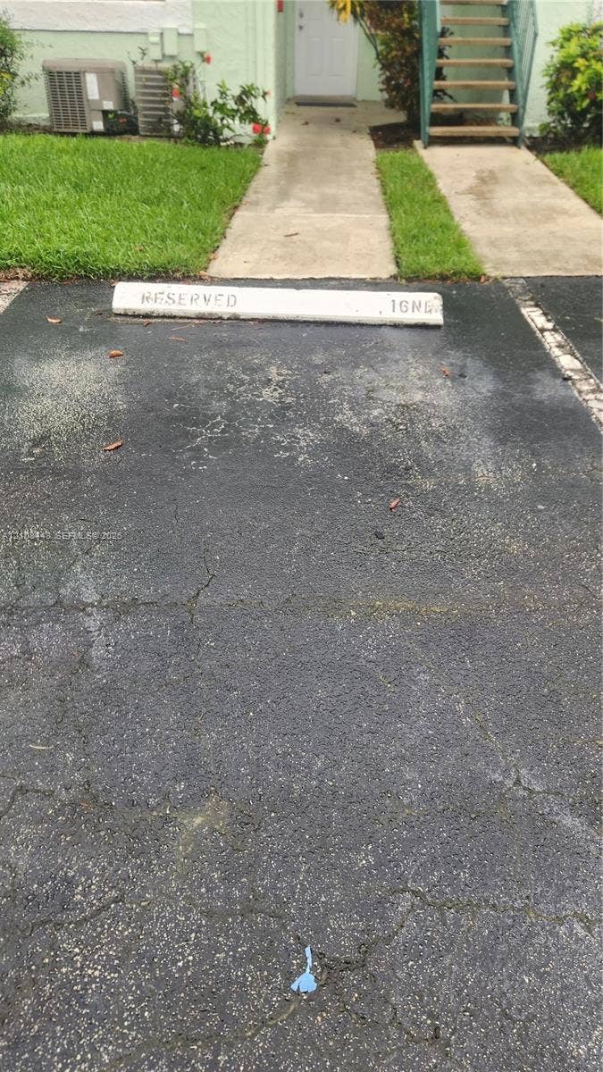 4018 NW 87th Avenue, #4018, Sunrise, Sunrise, FL 33351 Designated parking space with concrete bumper, asphalt surface, and concrete walkway