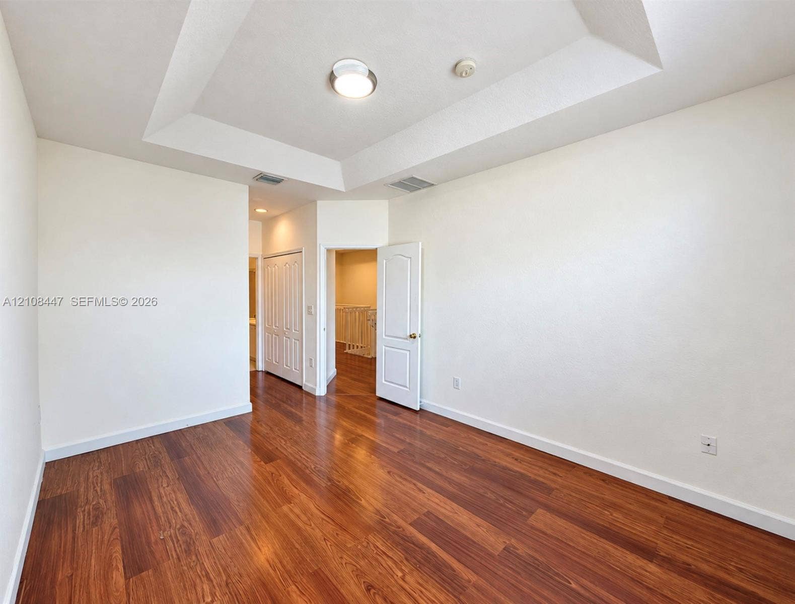 Tray ceiling with recessed lighting and wood-finish flooring