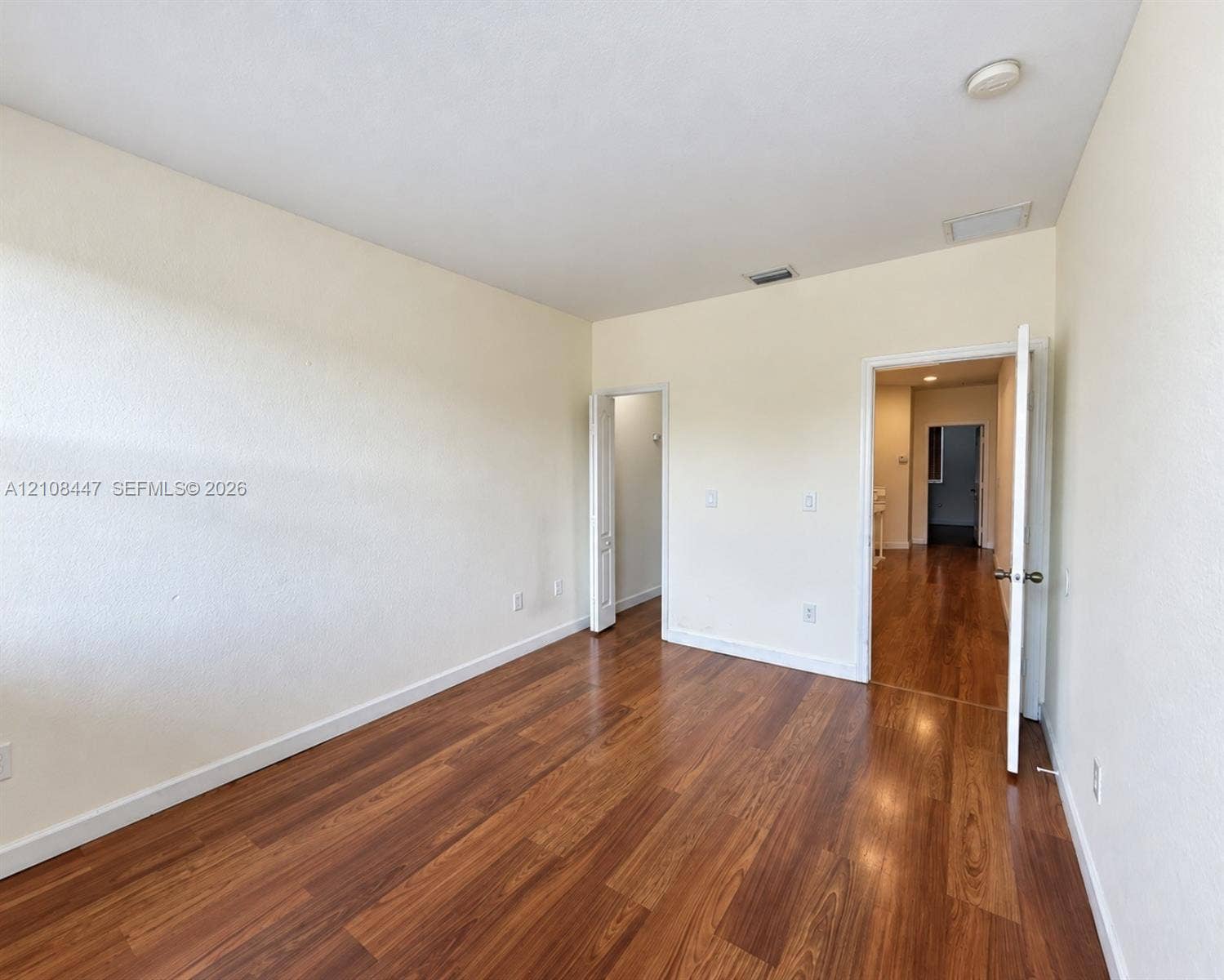 Room featuring wood-finish flooring and neutral-toned wall paint