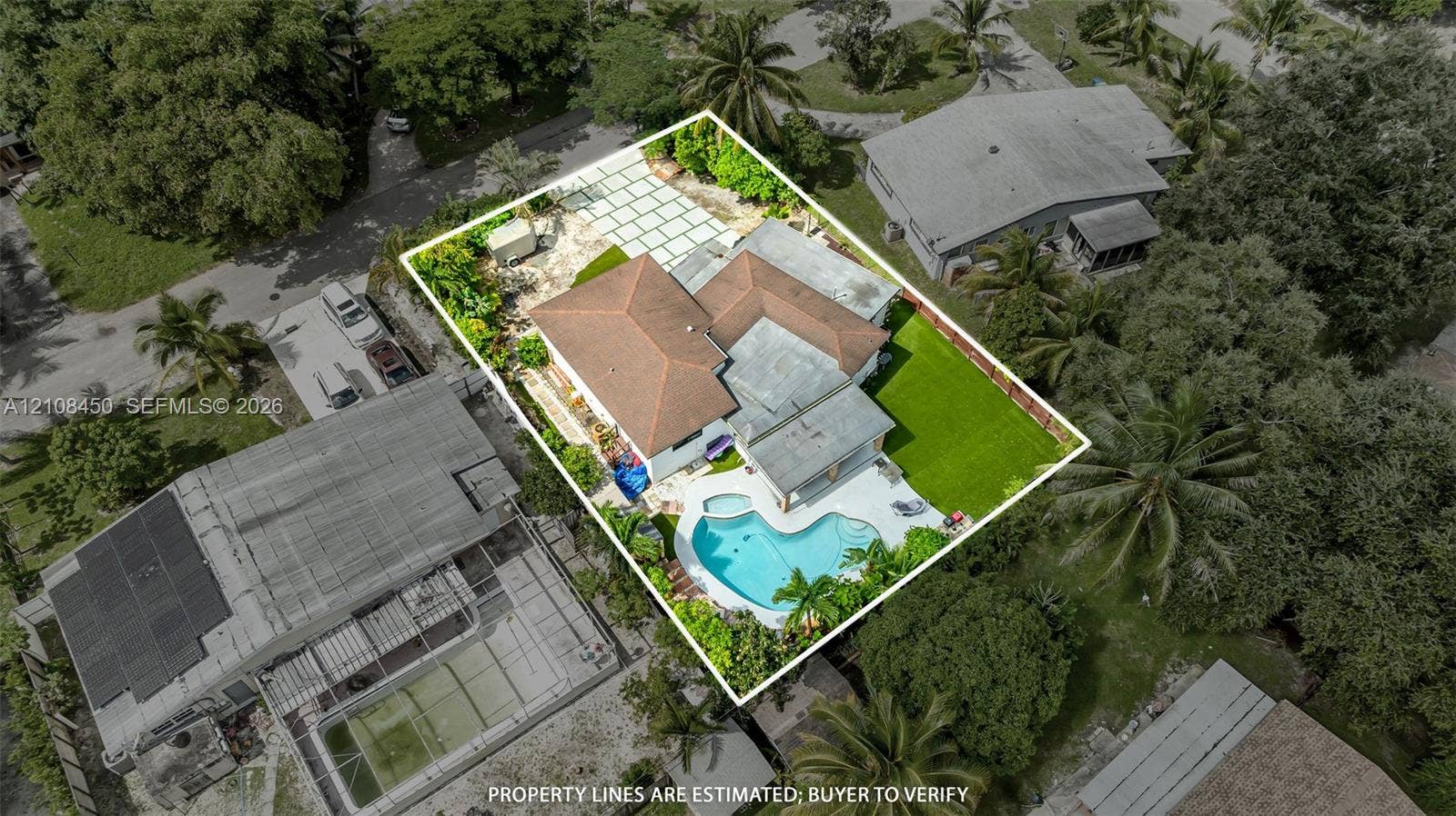 Aerial perspective featuring a shingled roof, a swimming pool with attached spa, a paved patio, and a manicured lawn