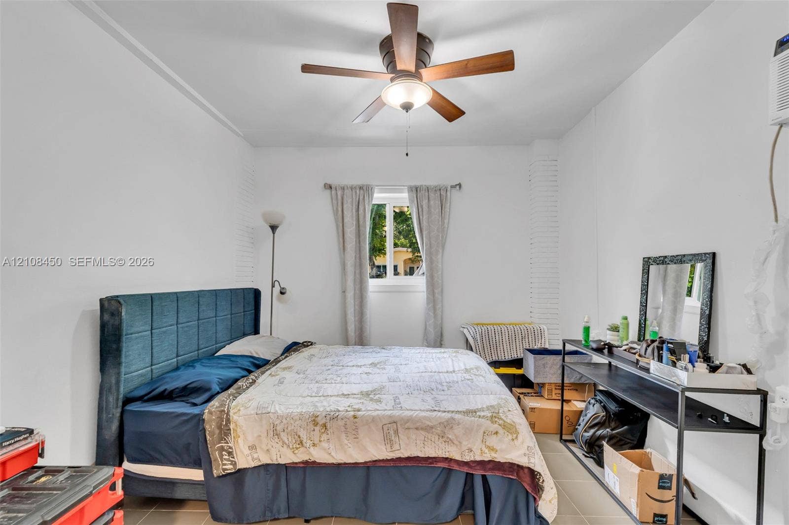 Room featuring a central ceiling fan with integrated lighting, a horizontal slider window, and textured masonry wall detailing