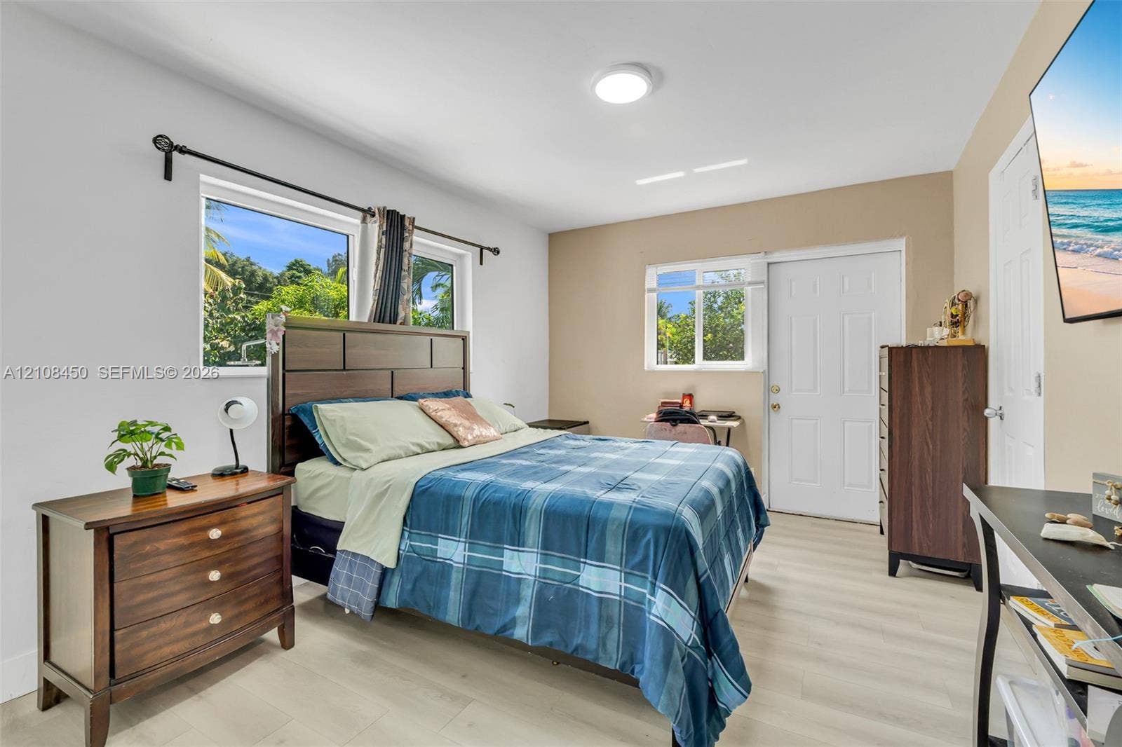 Light-toned wood-finish flooring, dual-pane windows, and a solid-panel exterior door
