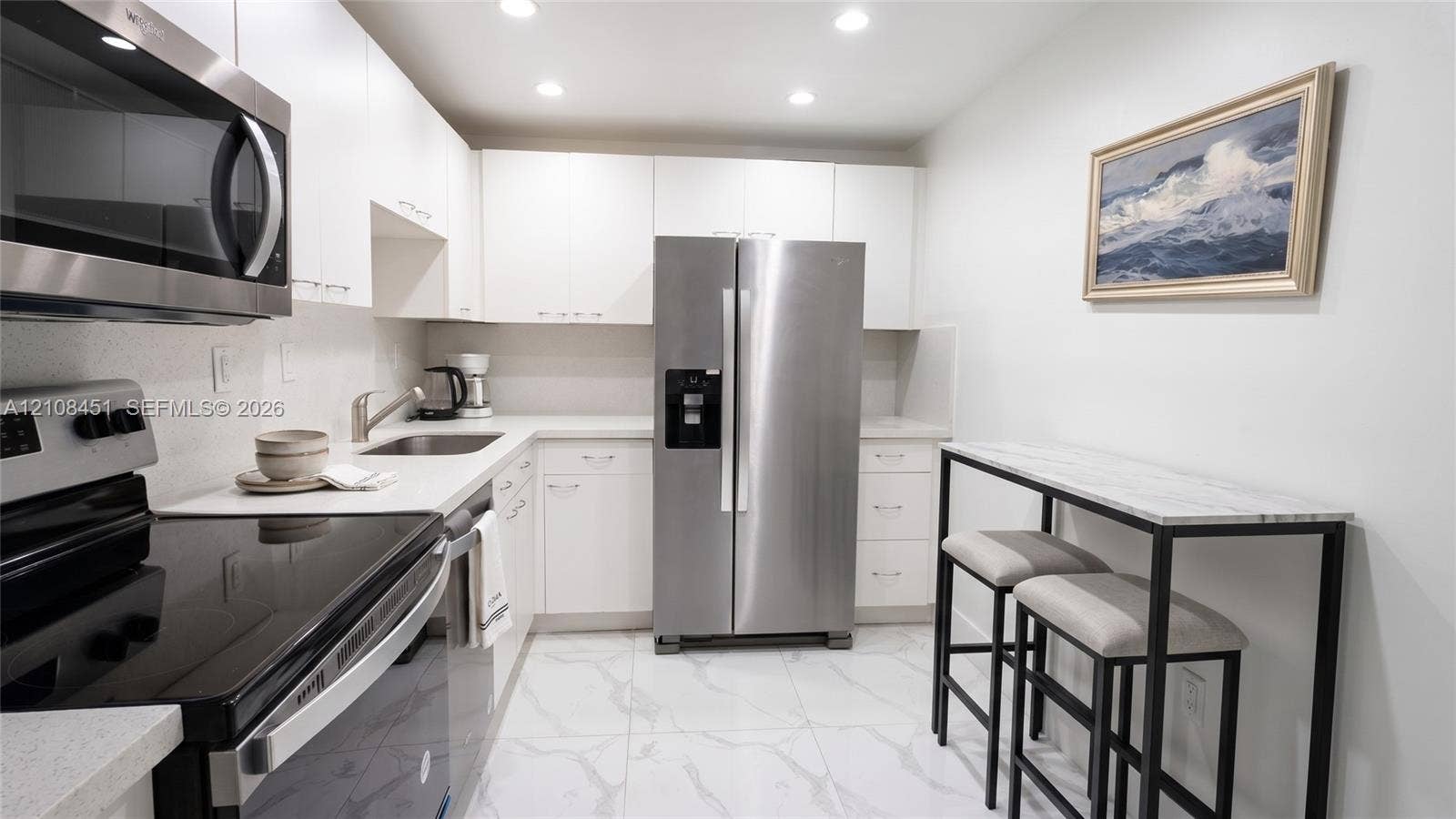 3701 N Country Club Drive, #701, Aventura, Aventura, FL 33180 Kitchen featuring white flat-panel cabinetry, stainless steel appliances, solid surface countertops, and white tile flooring with grey veining