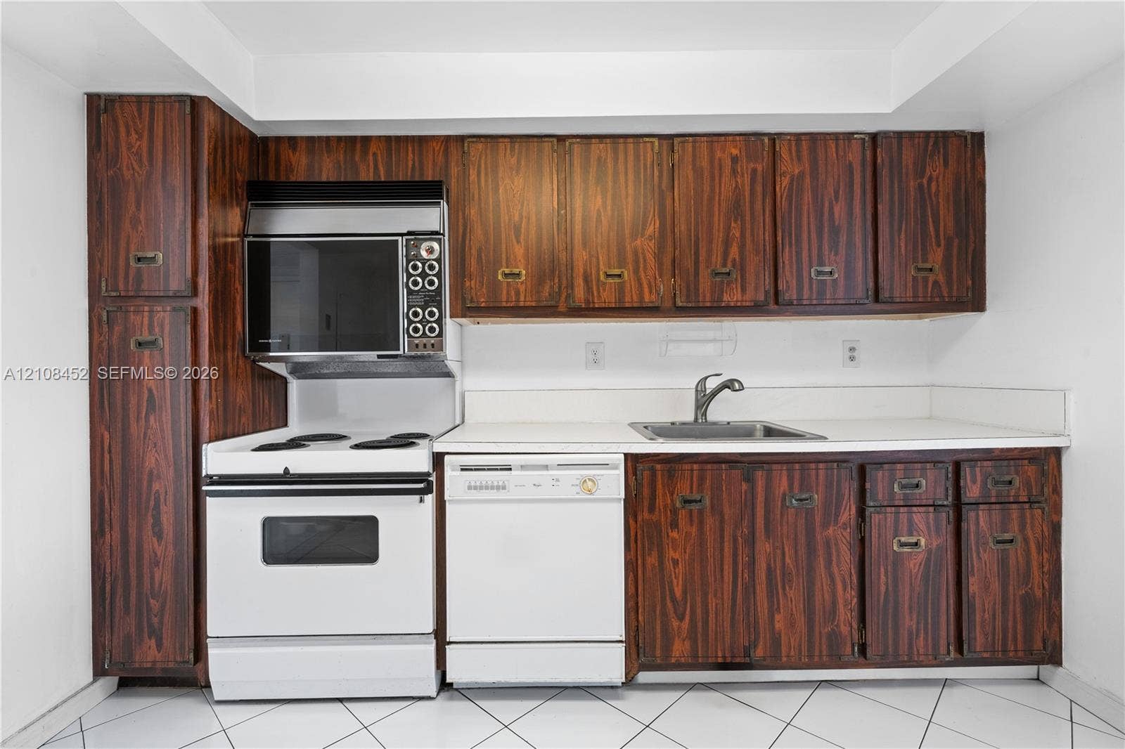 1000 Parkview Drive, #809, Hallandale Beach, FL 33009 Kitchen featuring wood-grain cabinetry, solid surface countertops, white electric range with built-in microwave, integrated dishwasher, and stainless steel sink