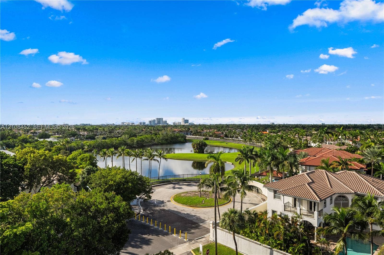 1000 Parkview Drive, #809, Hallandale Beach, FL 33009 Aerial perspective featuring a tiled-roof residence, expansive water feature, mature palm trees, and panoramic cityscape horizon