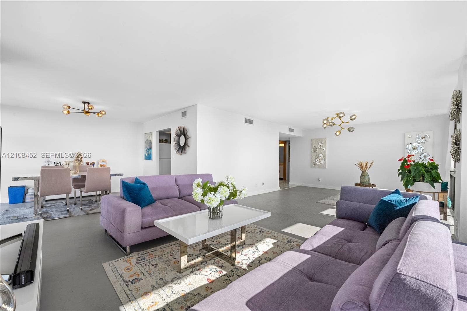 1000 Parkview Drive, #809, Hallandale Beach, FL 33009 Open-concept interior featuring smooth flooring and two multi-arm modern light fixtures